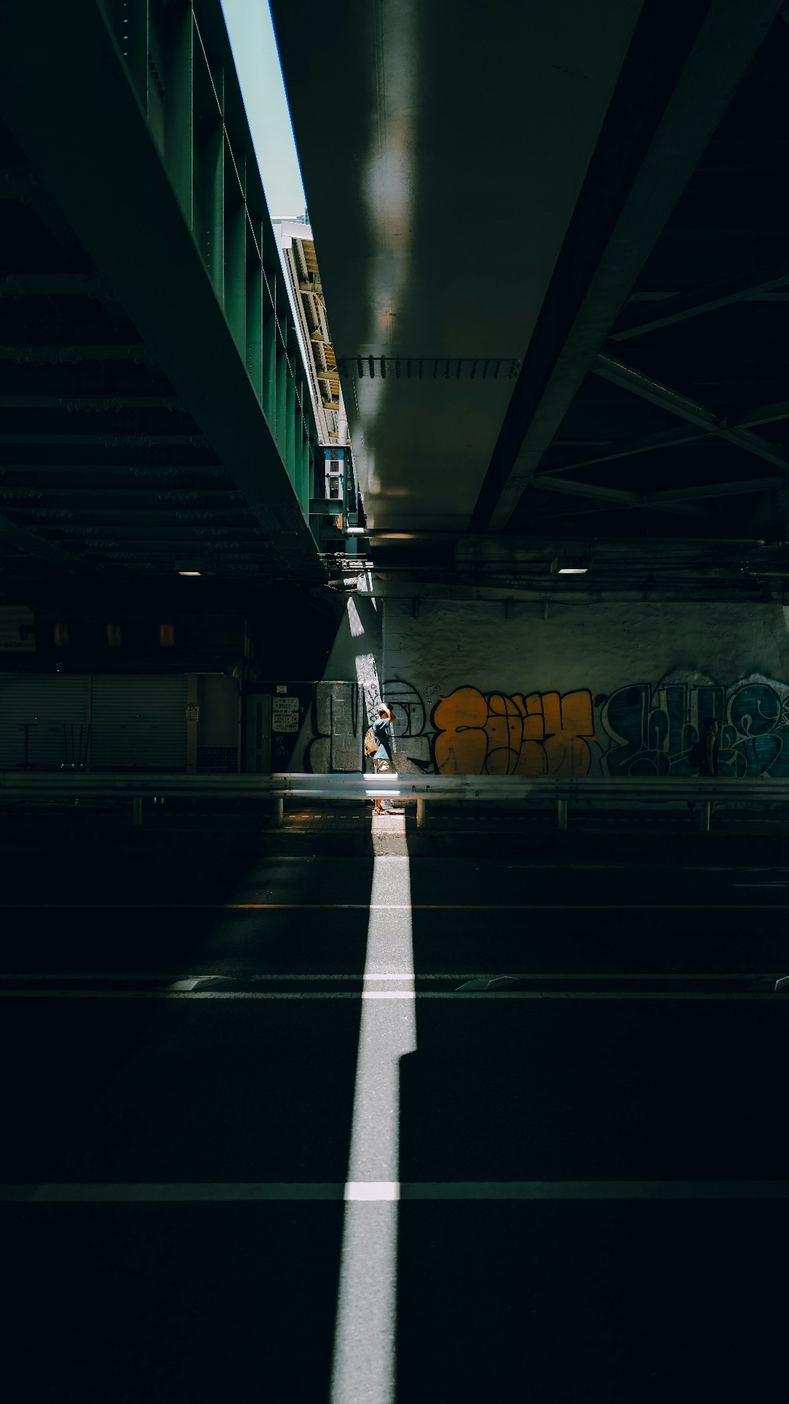Bóng tuyến tính dưới cầu với hình vẽ graffiti trên tường