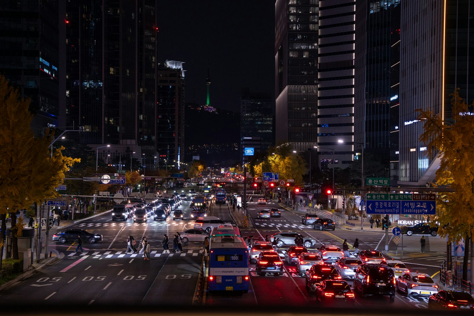 夜の都市風景 車のライトと高層ビルが並ぶ交差点