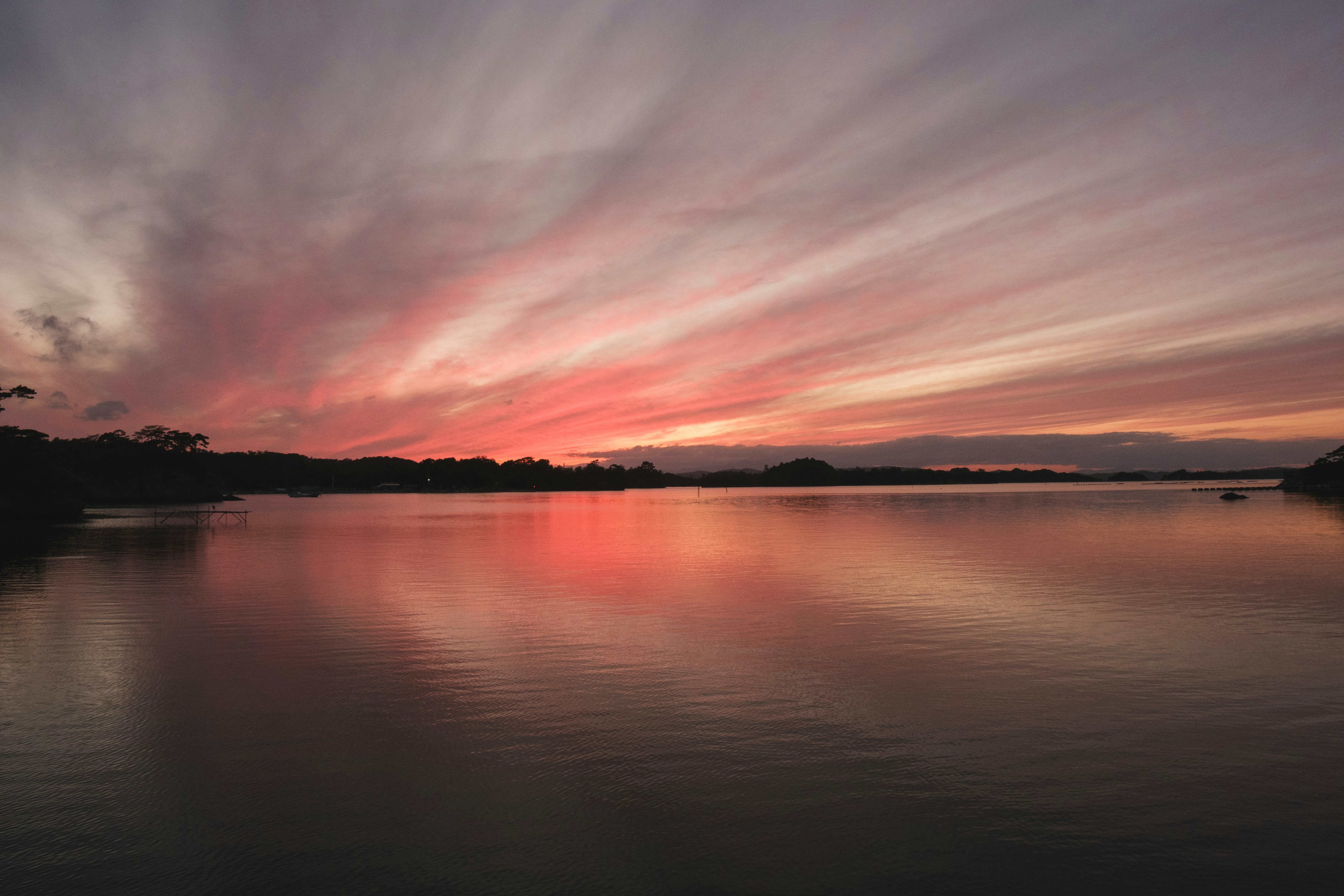 夕焼けの湖面に広がる静かな水辺の風景