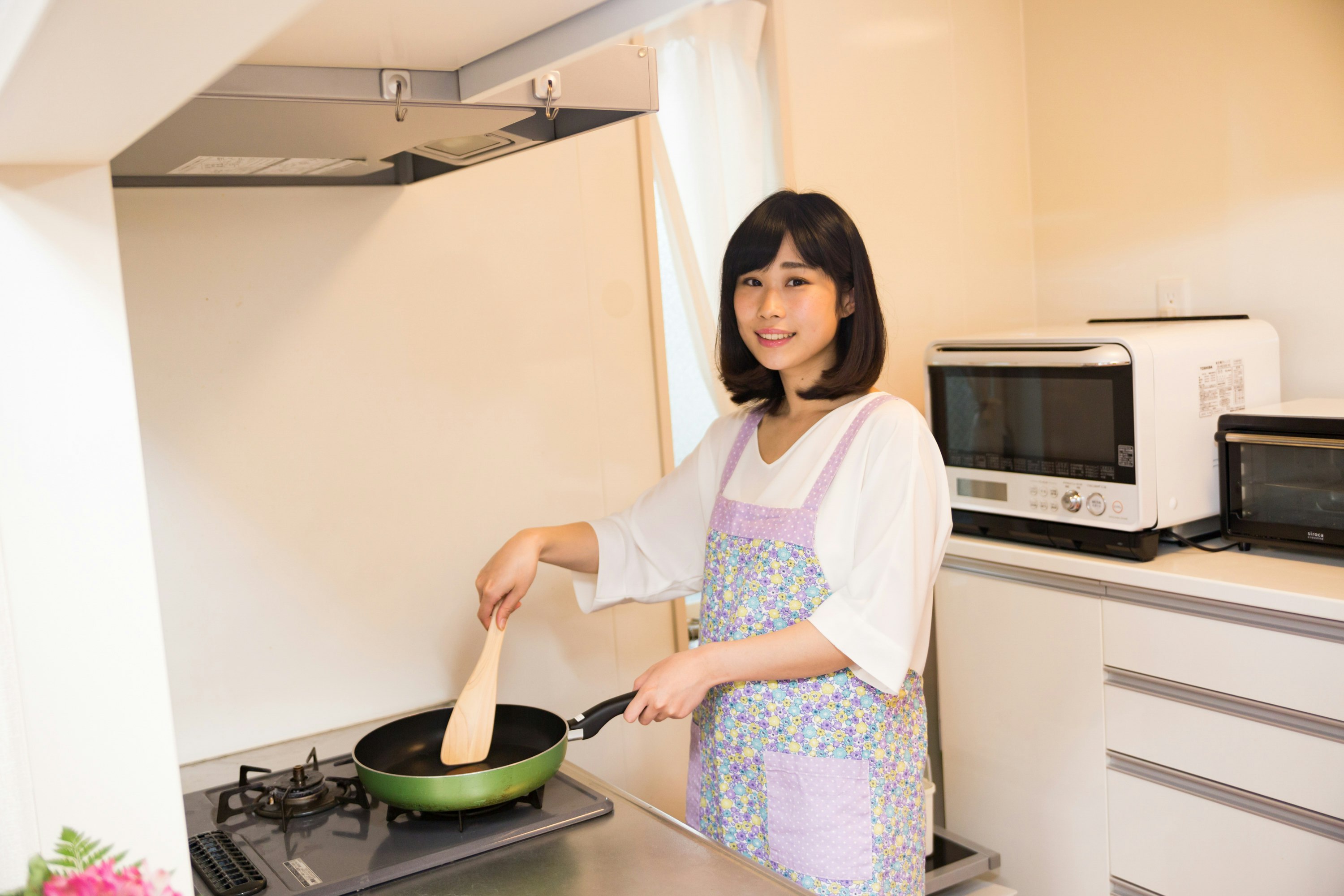 femme tenant une poêle dans une cuisine