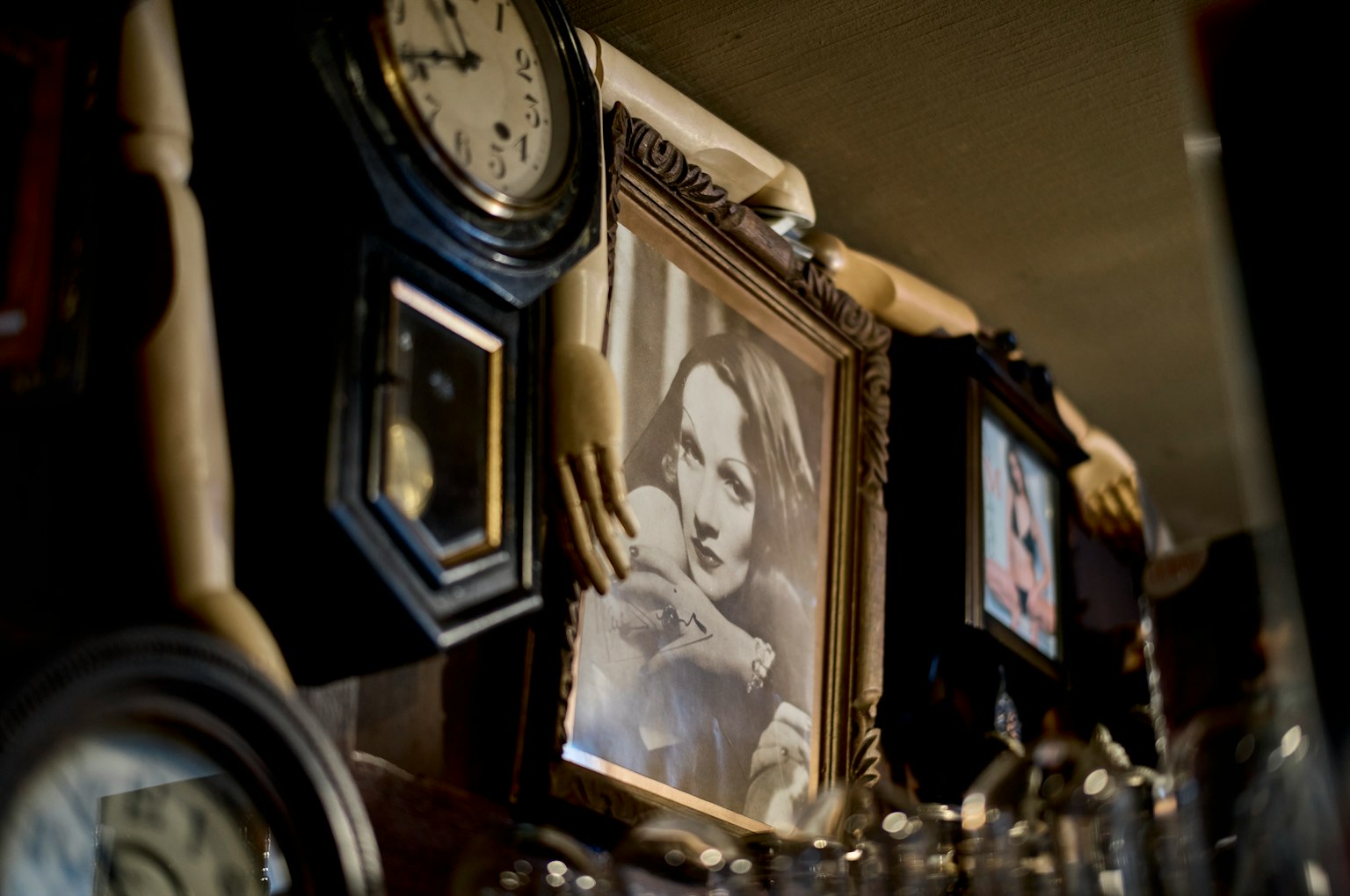 A section of a wall adorned with vintage photographs and clocks