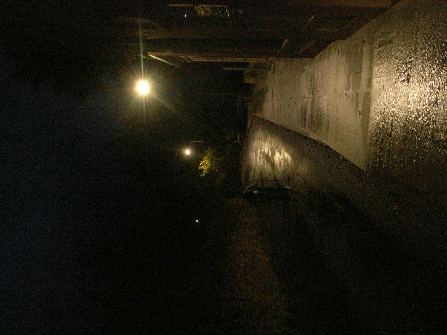 Calle iluminada por farolas de noche con un fondo oscuro