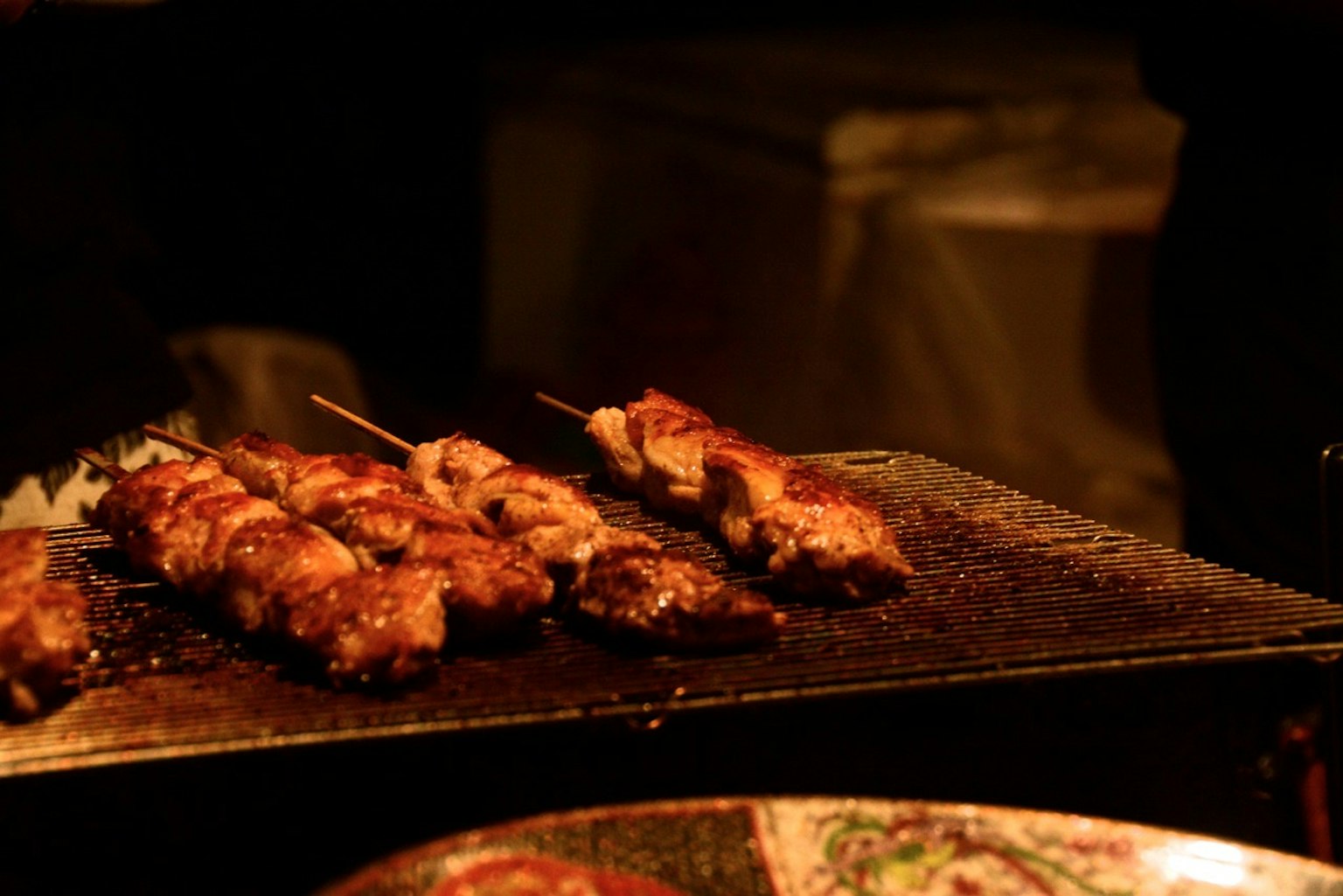 Spiedini di pollo grigliati su un barbecue di notte