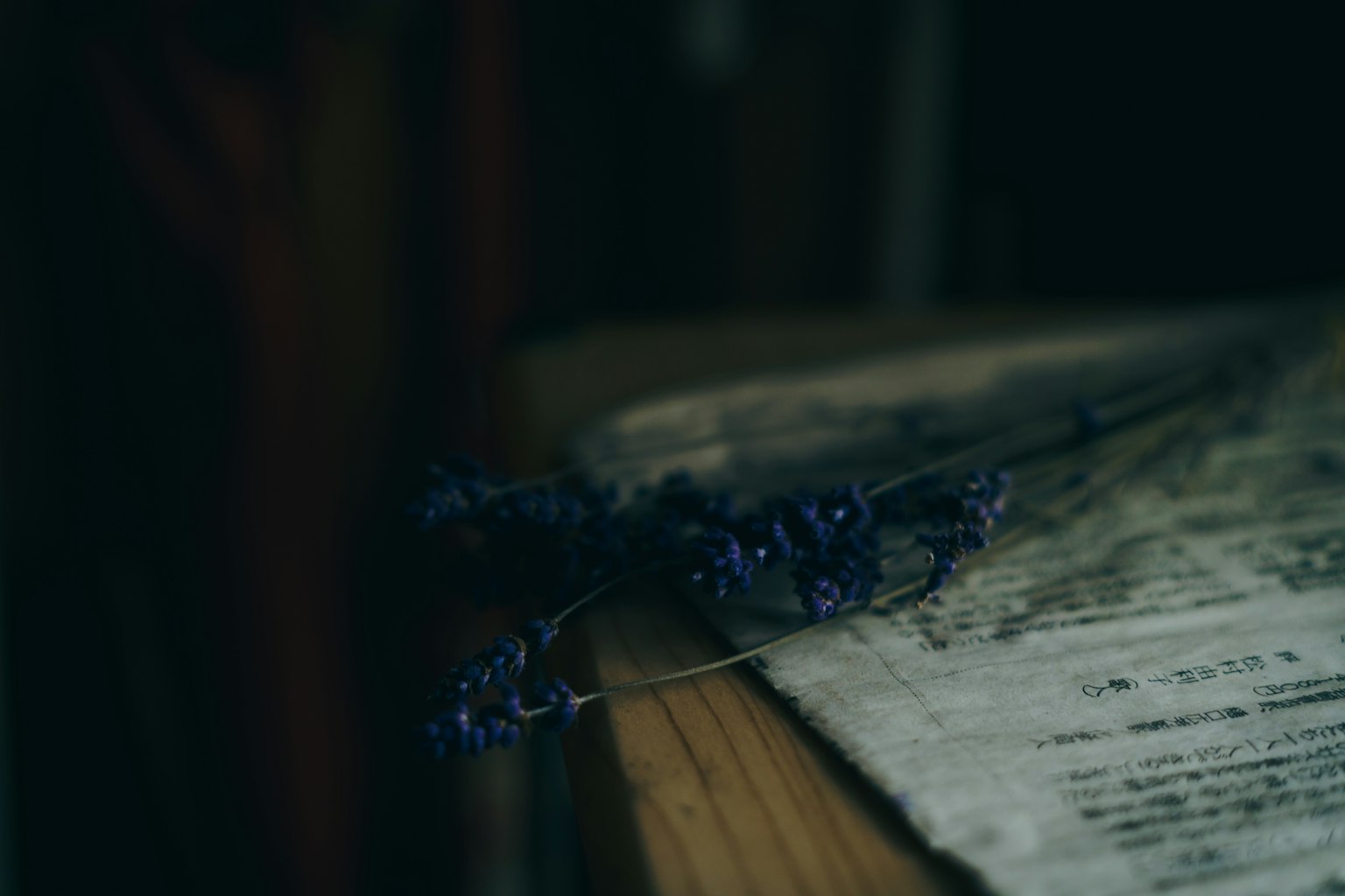 紫色の花が置かれた木製のテーブルと古い楽譜