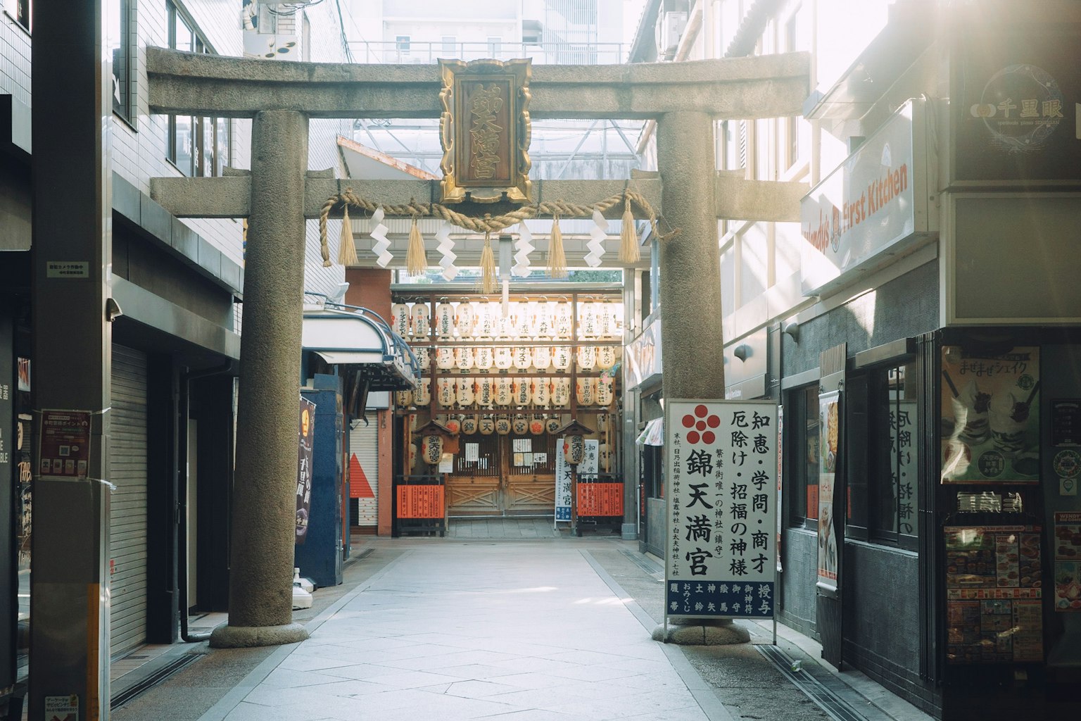Vista de una calle comercial con un torii