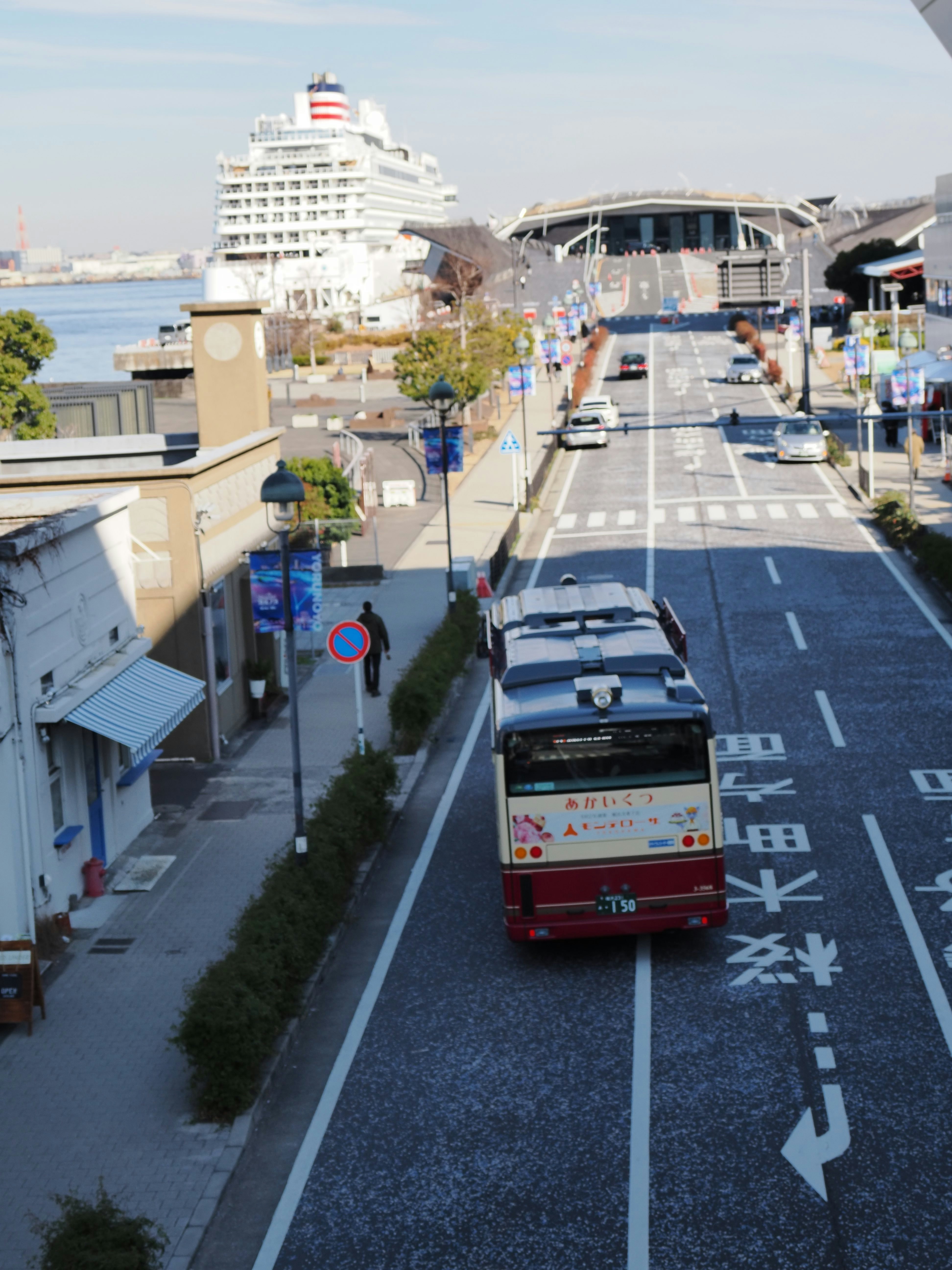 港沿いの通りを走る観光バスと客船の眺め