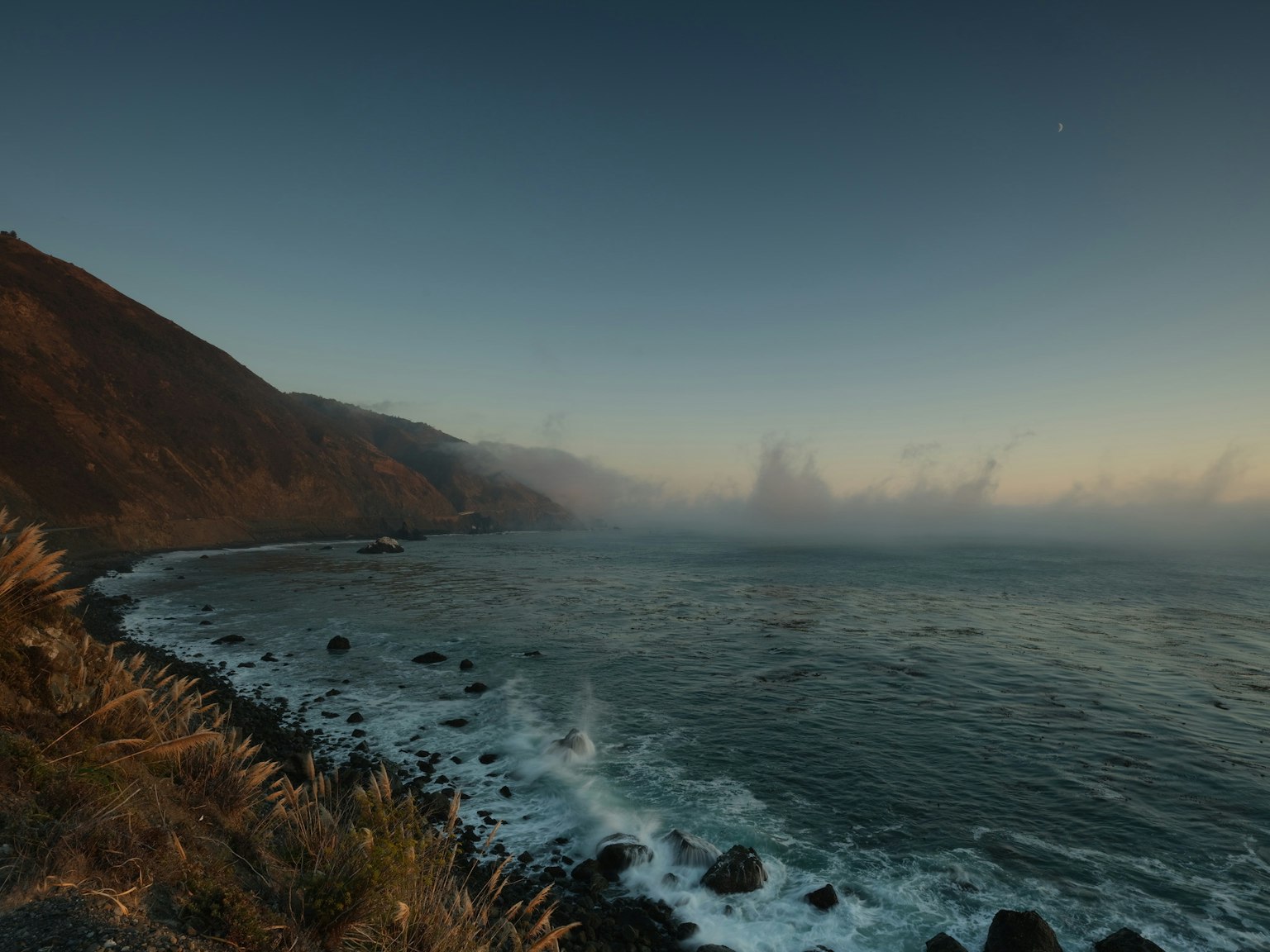Coastal view with mist and ocean at dusk