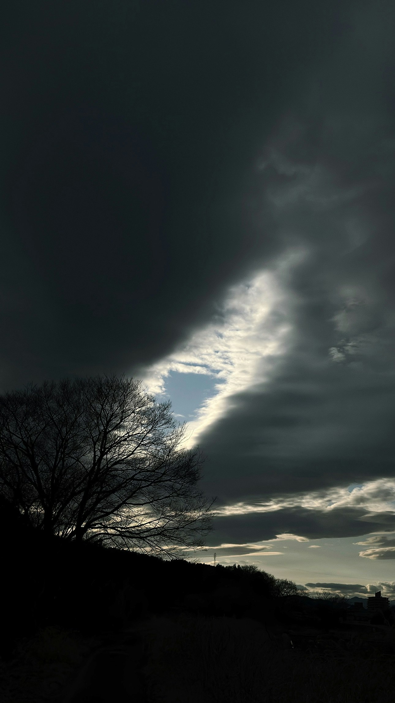 雲の切れ間から差す光と不穏な空模様