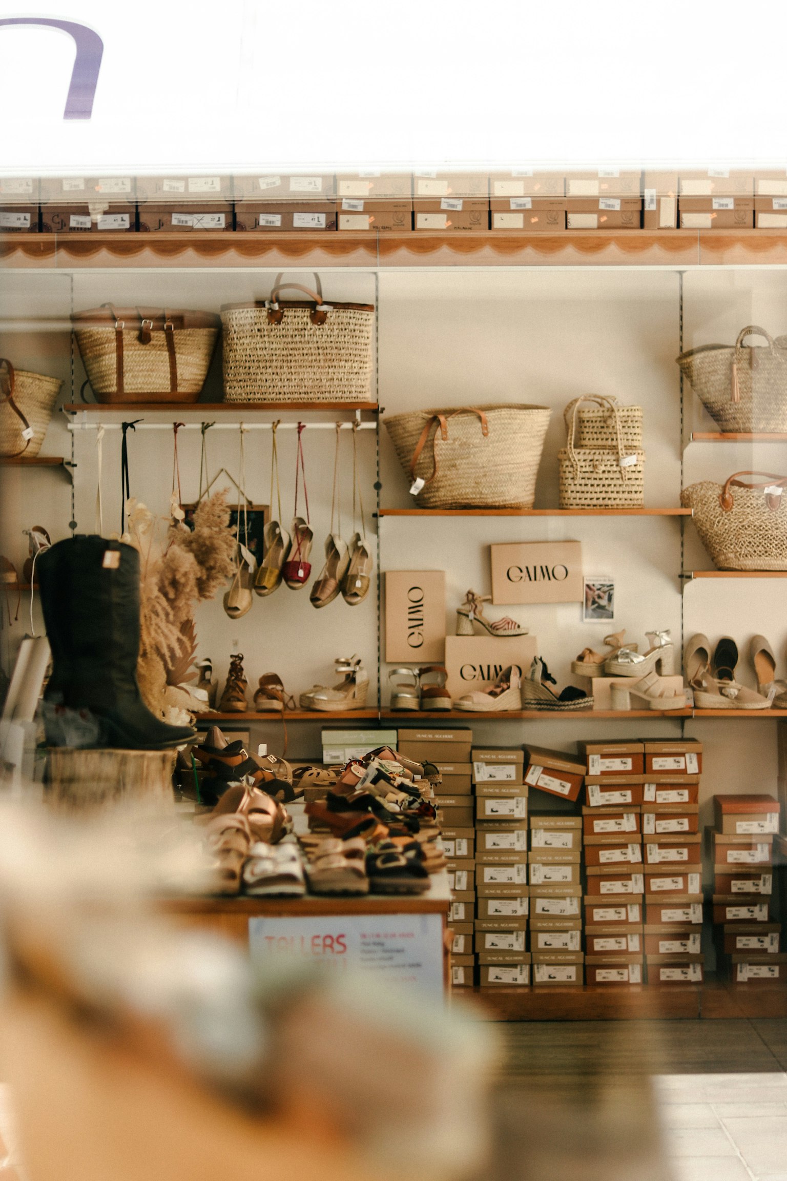 Interior toko yang stylish dengan rak kayu yang menampilkan berbagai keranjang dan sepatu