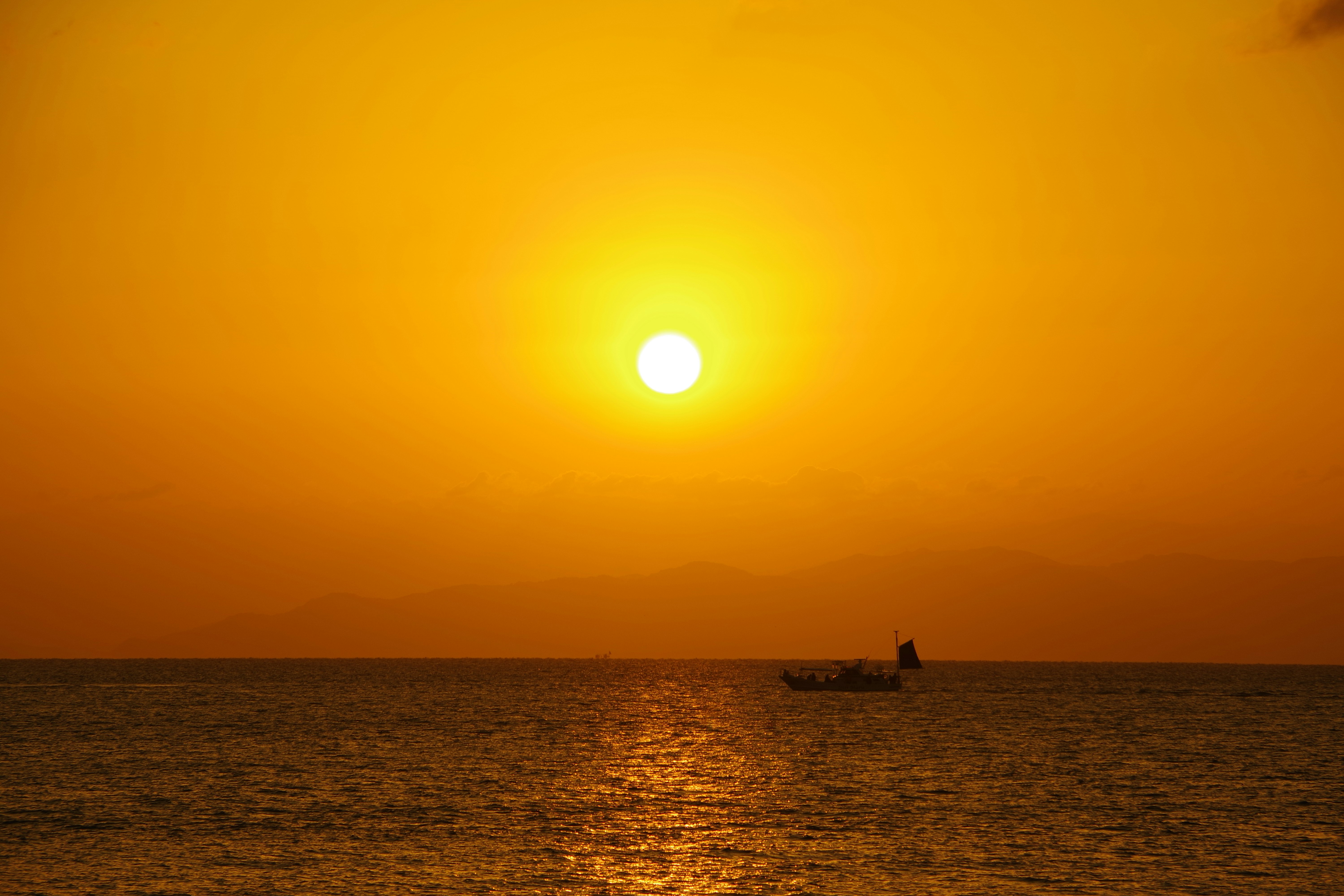Magnifique coucher de soleil sur l'océan avec un petit bateau sur l'eau