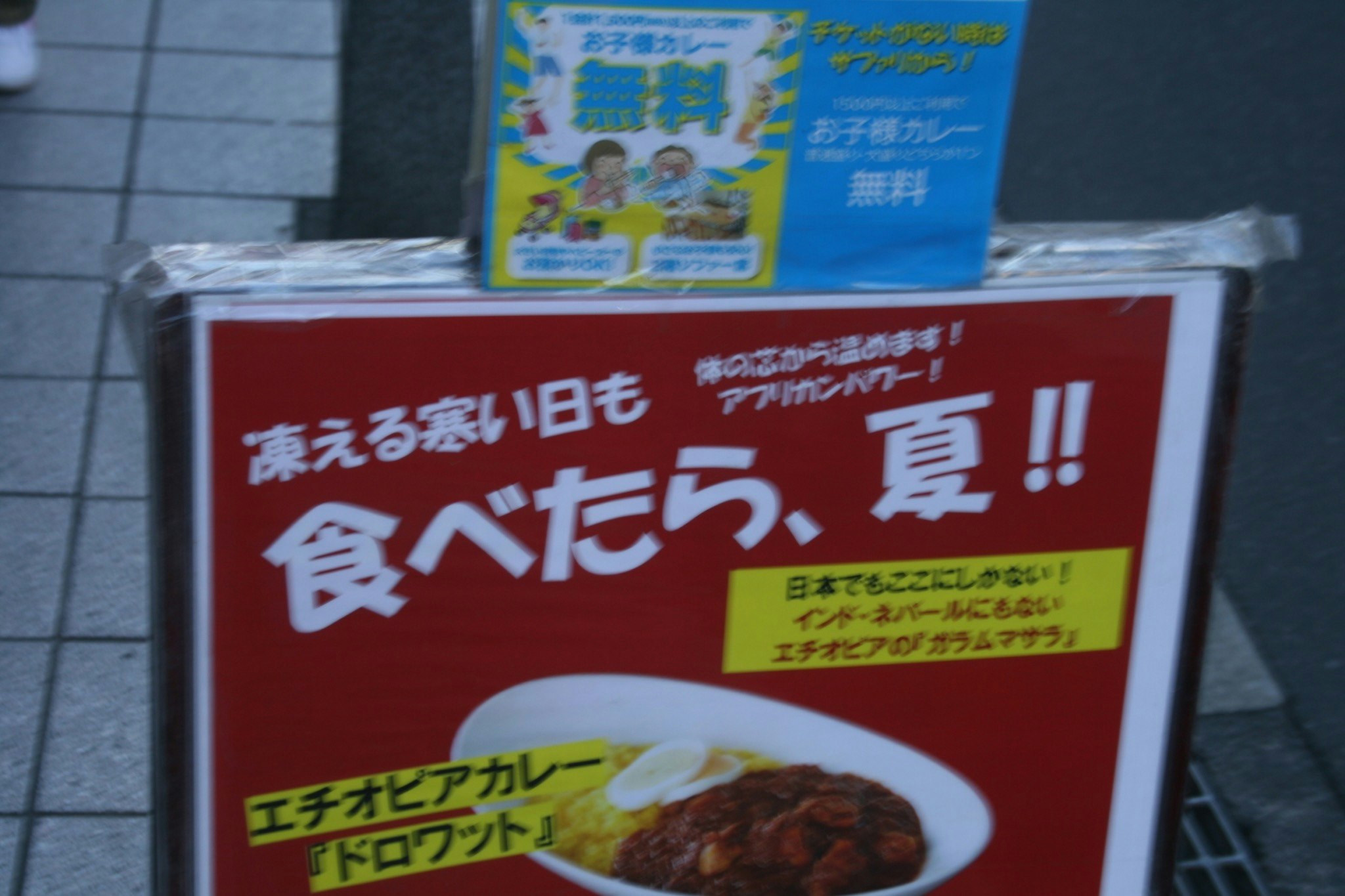 屋外の歩道に置かれた日本語の食べ方案内ポスター