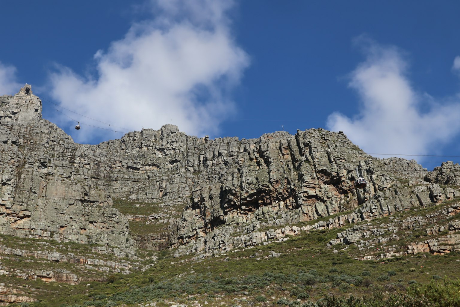 Paisaje montañoso rocoso con cielo azul y nubes dispersas