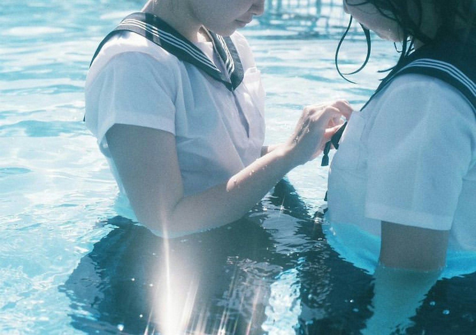 Two girls in sailor uniforms sharing an intimate moment in water