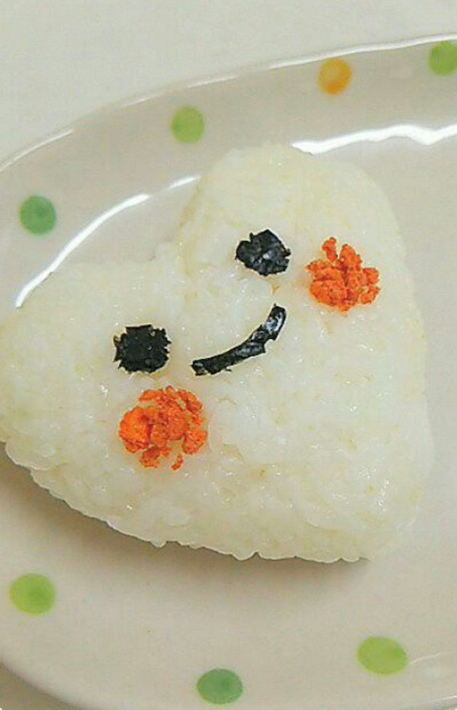 Bola de arroz en forma de corazón con ojos negros y cara sonriente