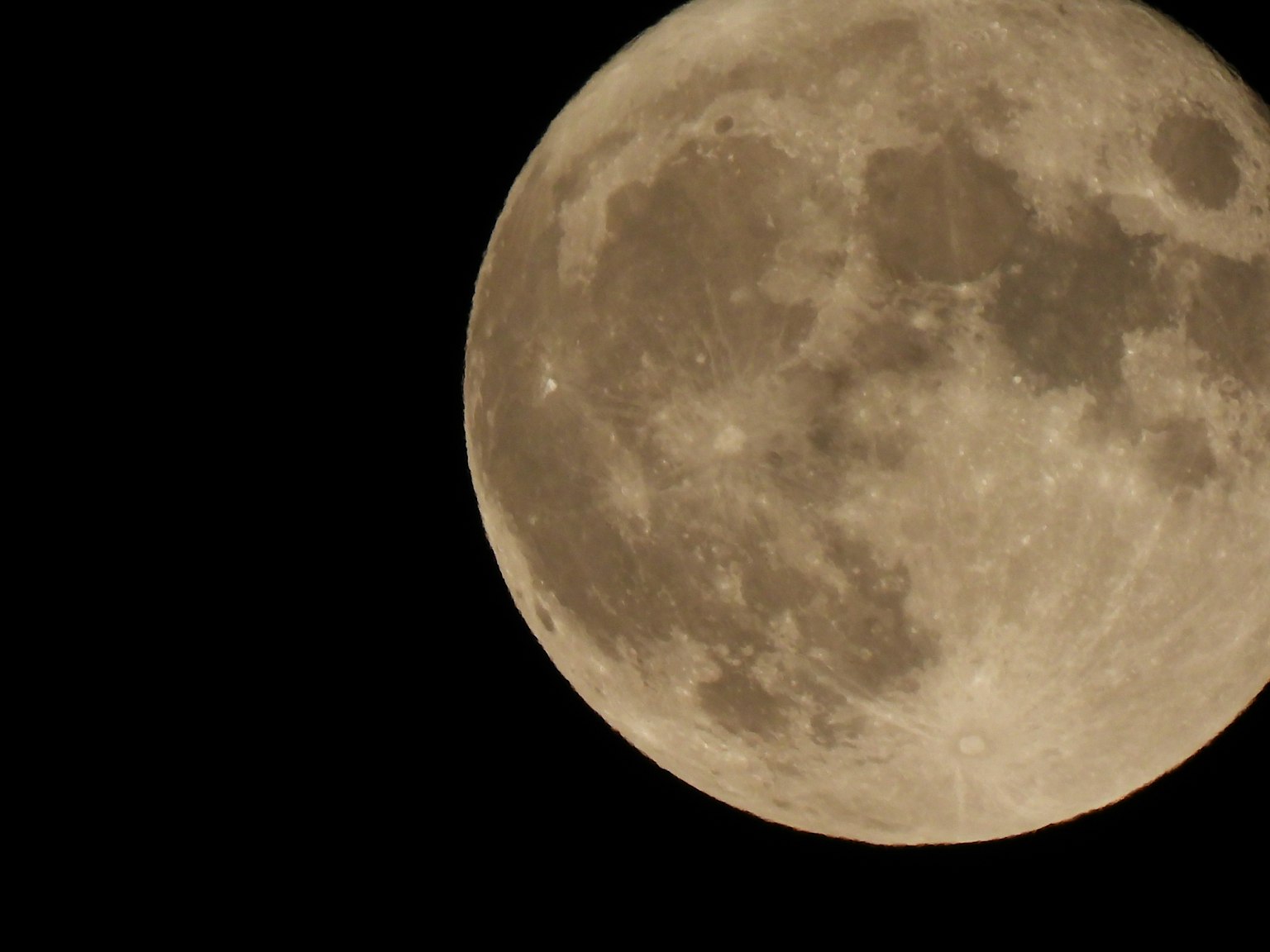 Helle Vollmond vor schwarzem Hintergrund