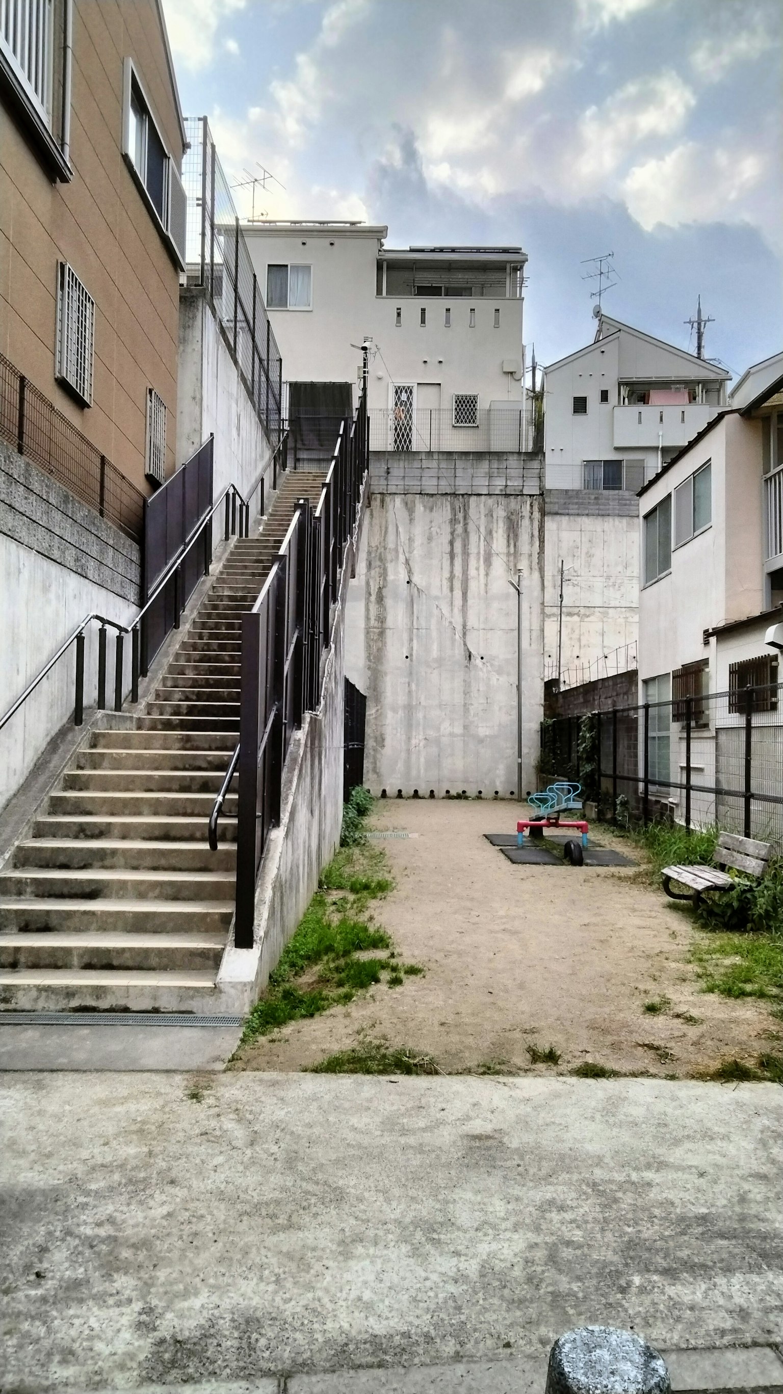 Área residencial con escaleras y una pared de concreto