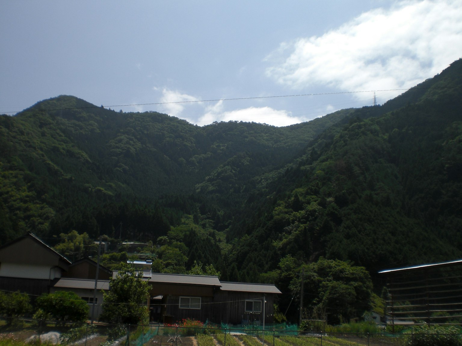 Ländliche Landschaft umgeben von grünen Bergen
