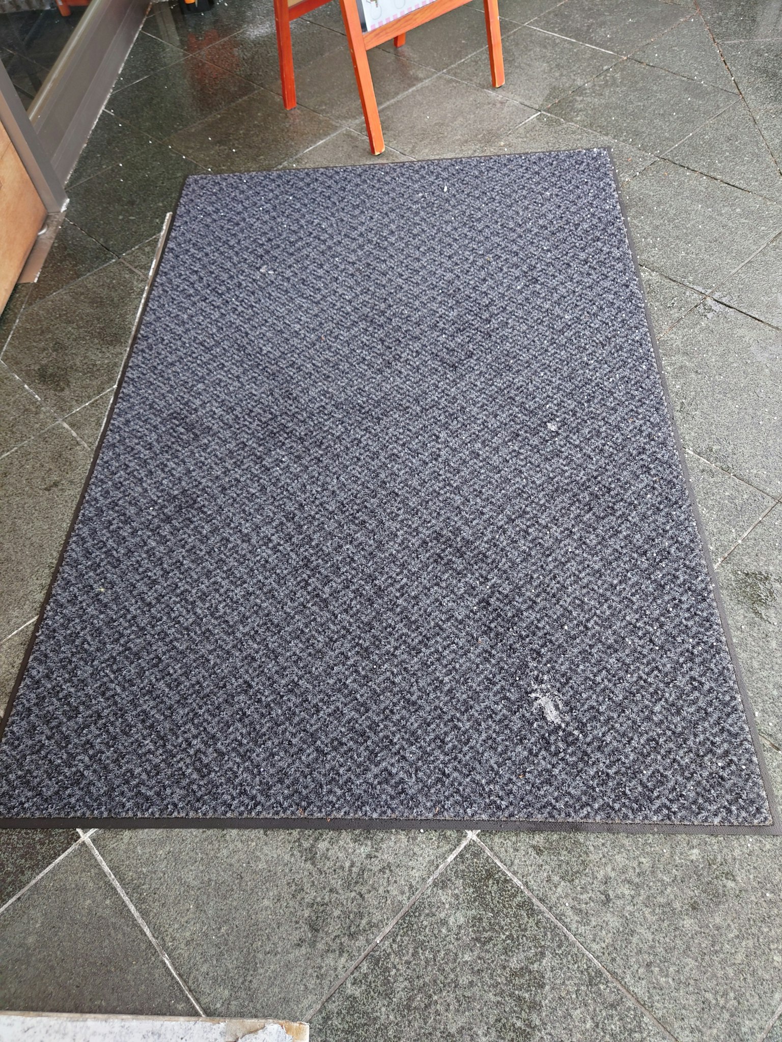 Schwarze Matte auf einem Steinboden platziert