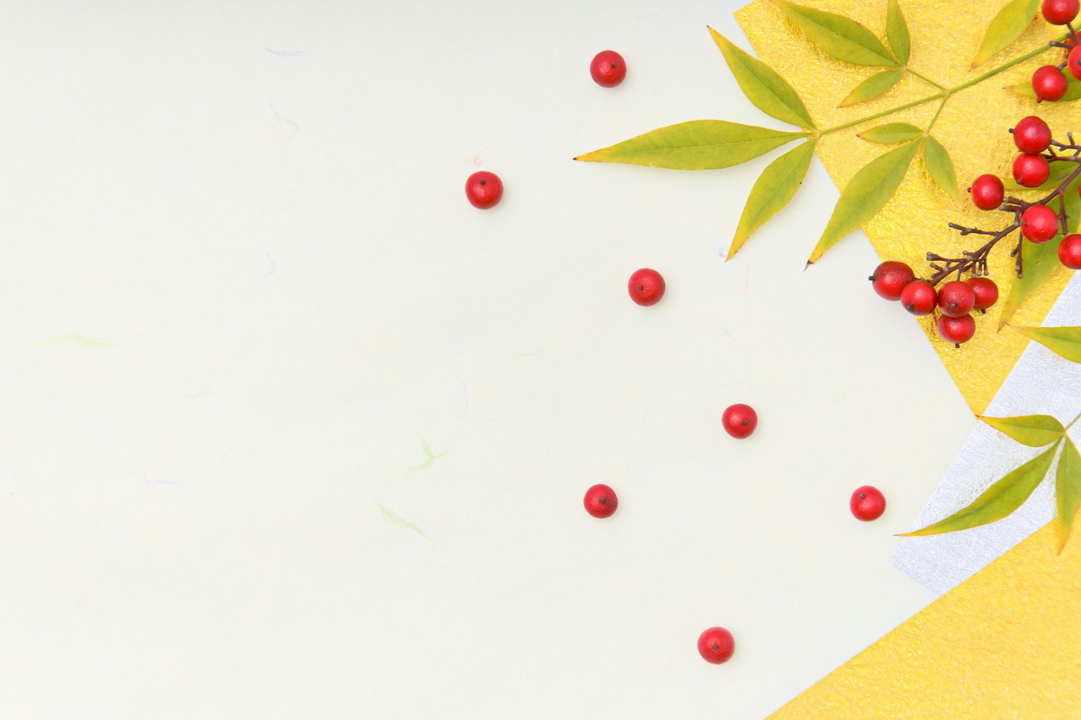 Bild mit verstreuten roten Beeren und grünen Blättern auf gelbem Hintergrund
