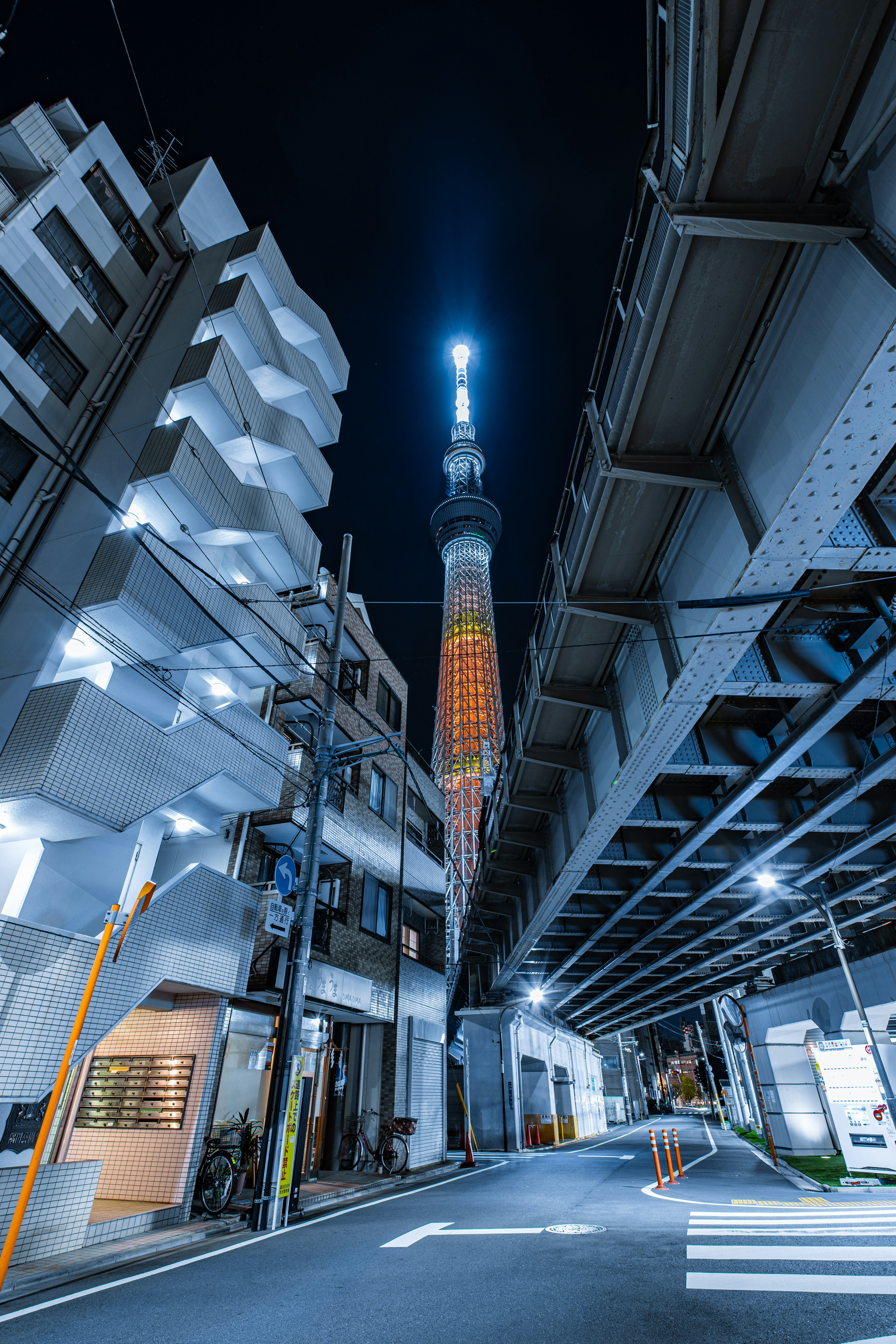 高層ビルに囲まれた夜の通りと東京スカイツリーの夜景