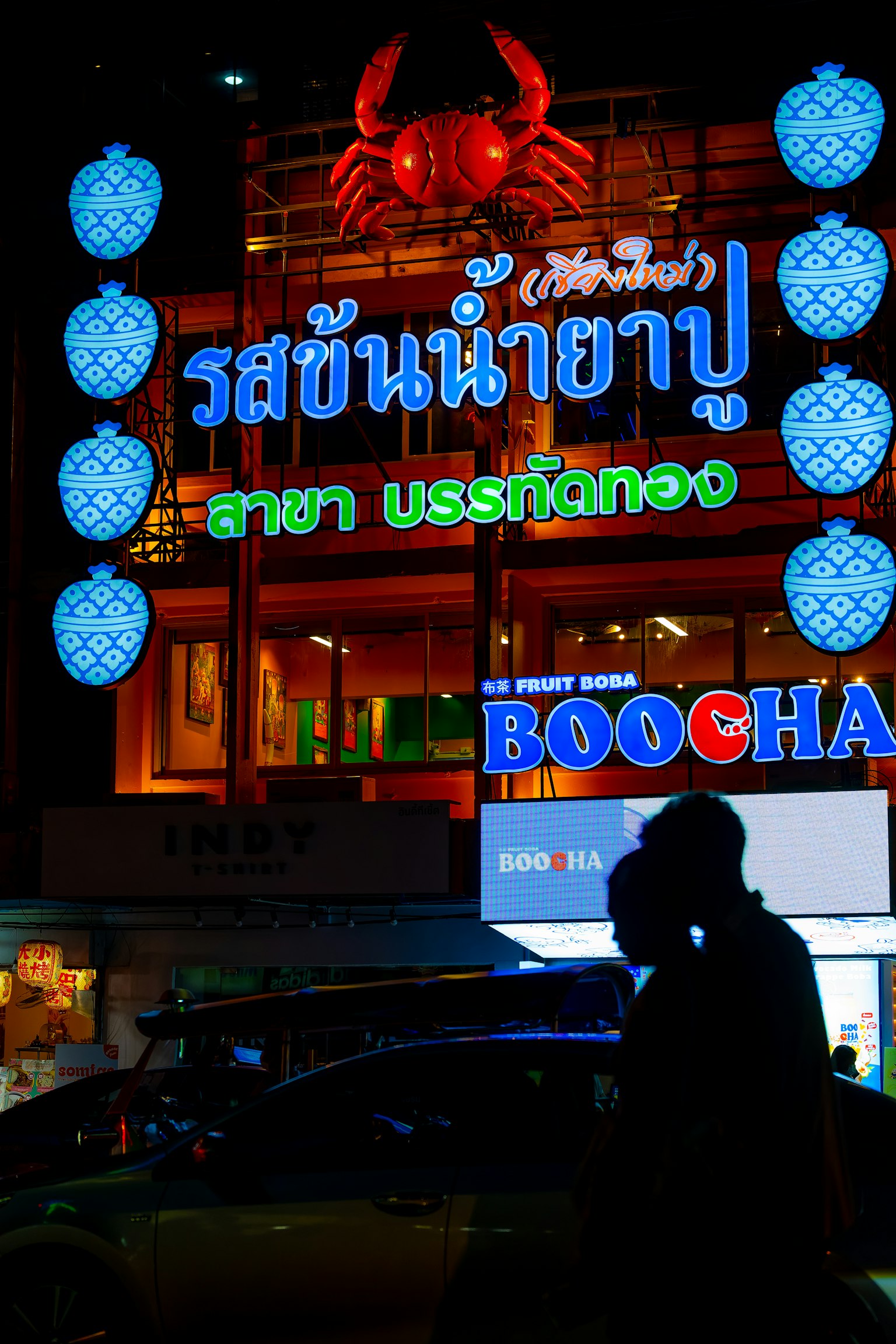 เงาของคู่รักหน้าป้ายร้านอาหารที่สว่างในตอนกลางคืน