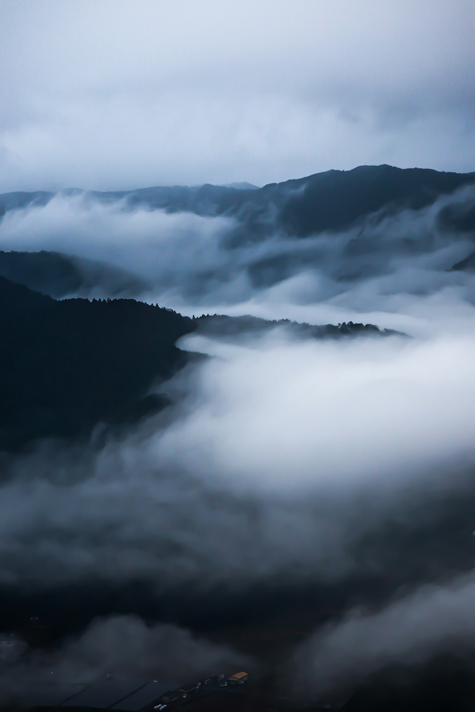 Paysage de montagnes couvertes de brume avec une teinte bleue