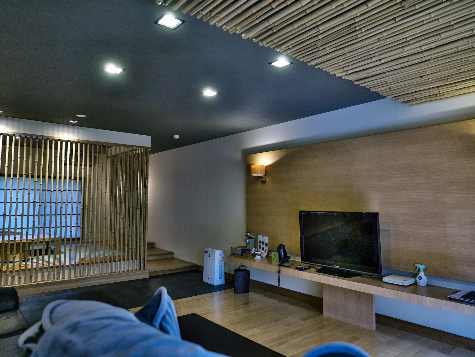 การออกแบบภายในห้องนั่งเล่นสมัยใหม่พร้อมเพดานไม้และโซฟาและทีวีที่จัดเรียง