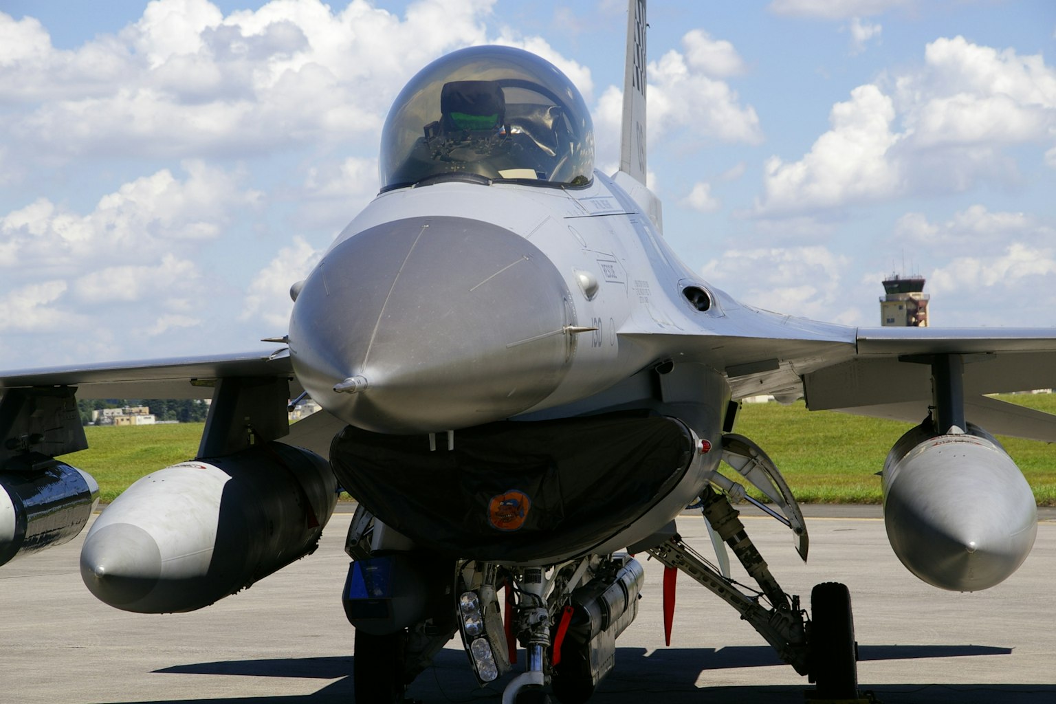 Vue de face du jet de chasse F-16 avec un ciel bleu et des nuages blancs en arrière-plan