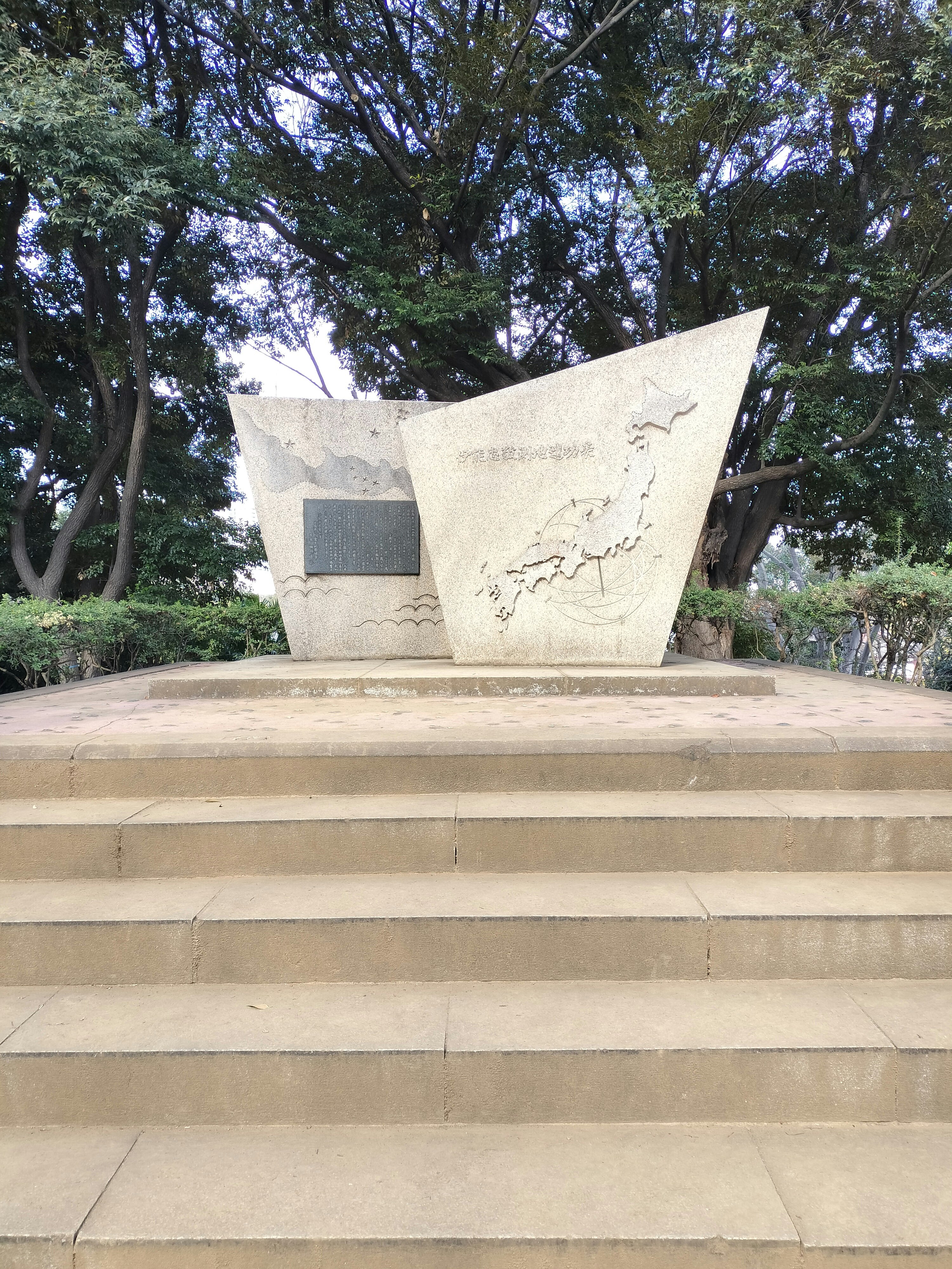 公園の石碑と彫刻のある広場