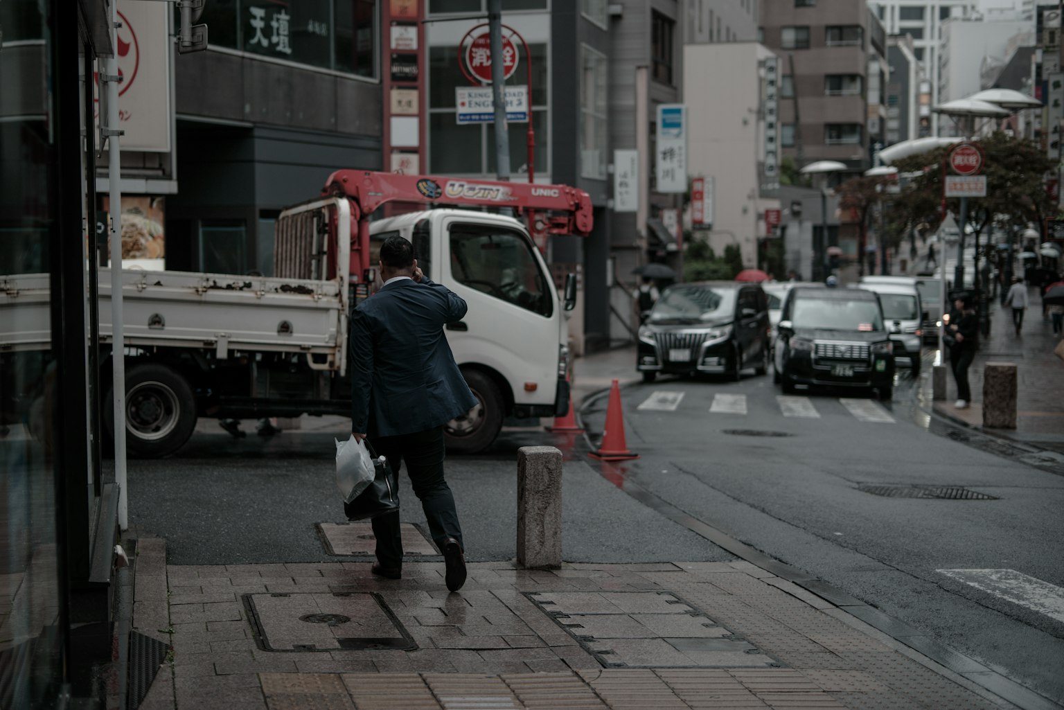 Geschäftsmann, der an einer städtischen Straßenecke mit einem Lastwagen geht