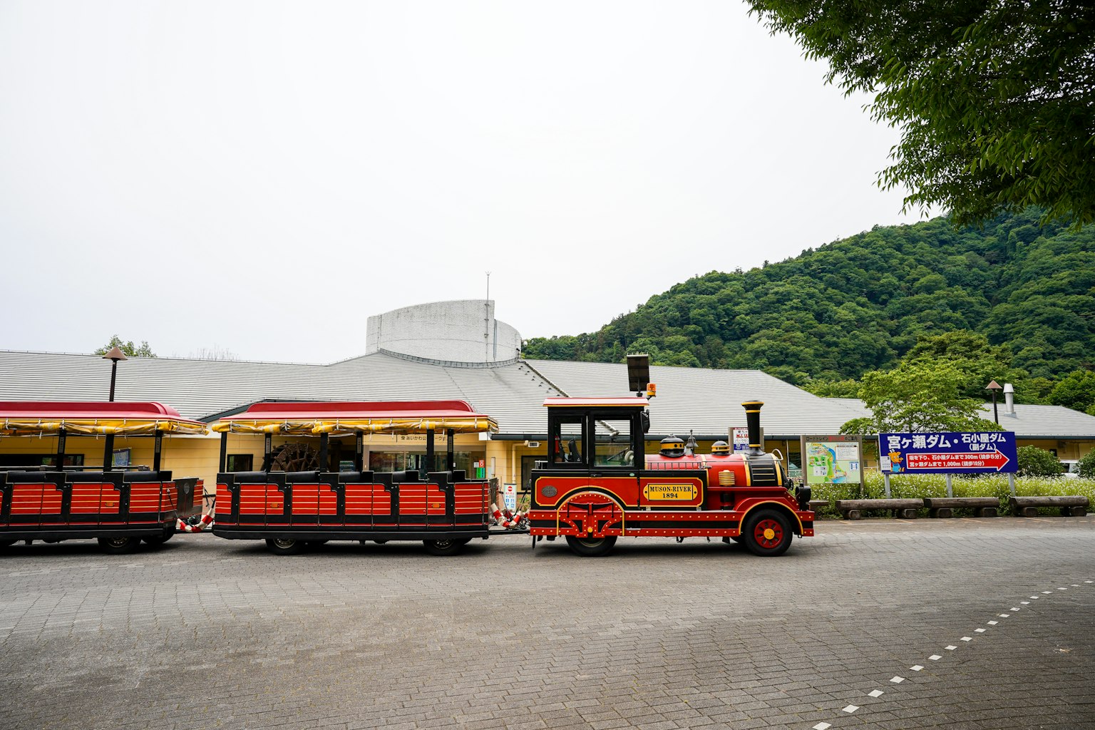 Roter Zug mit Berglandschaft im Hintergrund an einem Touristenort