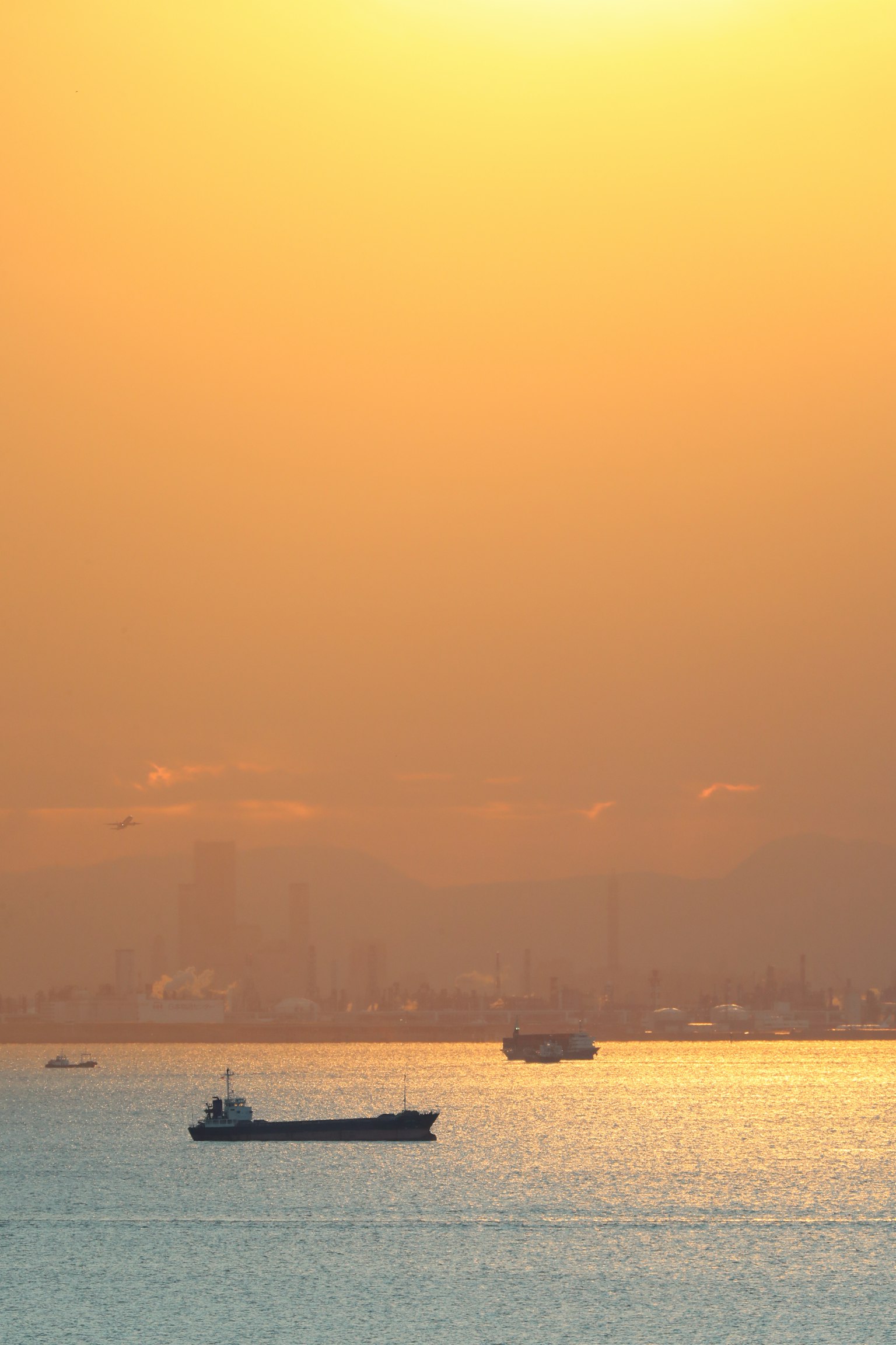 Hermoso atardecer reflejándose en el océano con un barco moviéndose suavemente sobre el agua