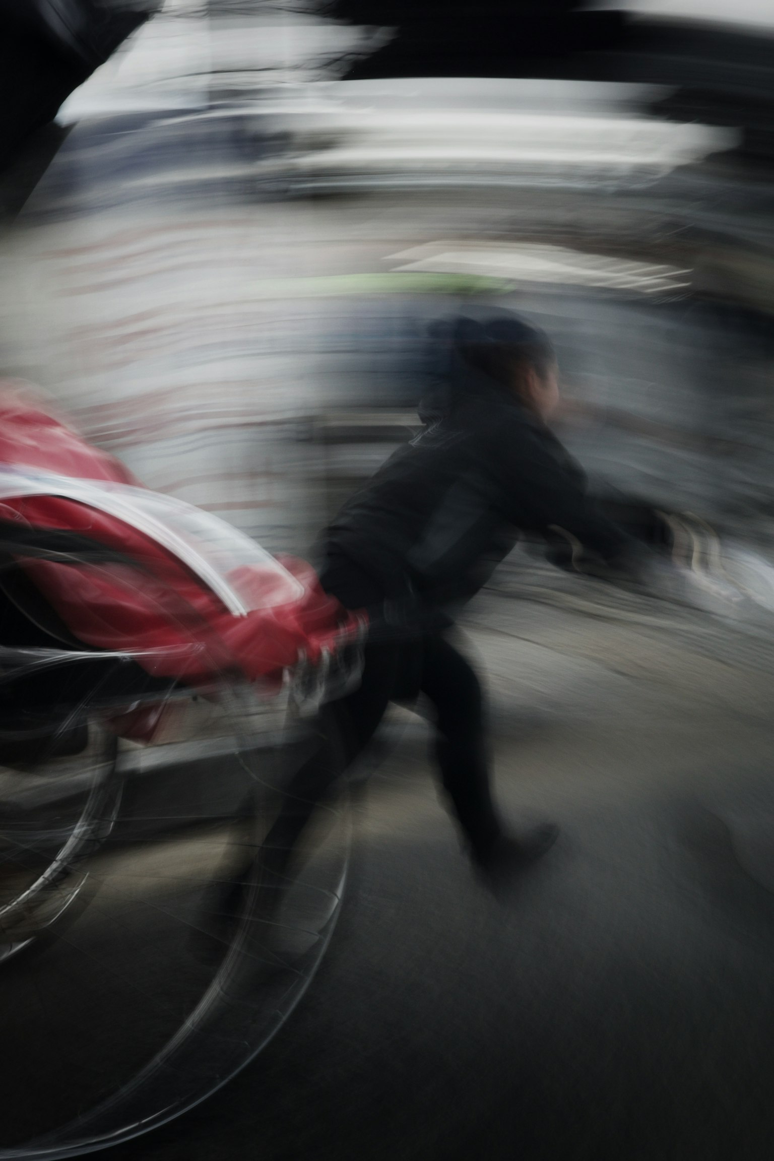 Verschwommene Aufnahme einer Person, die mit einem roten Fahrzeug läuft