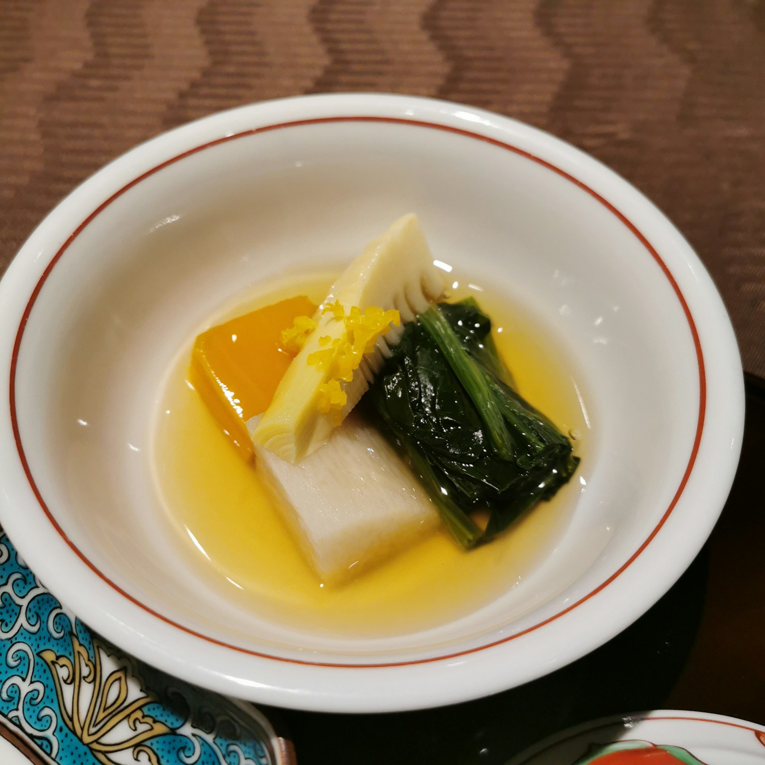 Un piatto con tofu bianco, verdure verdi e germogli di bambù servito in una salsa leggera