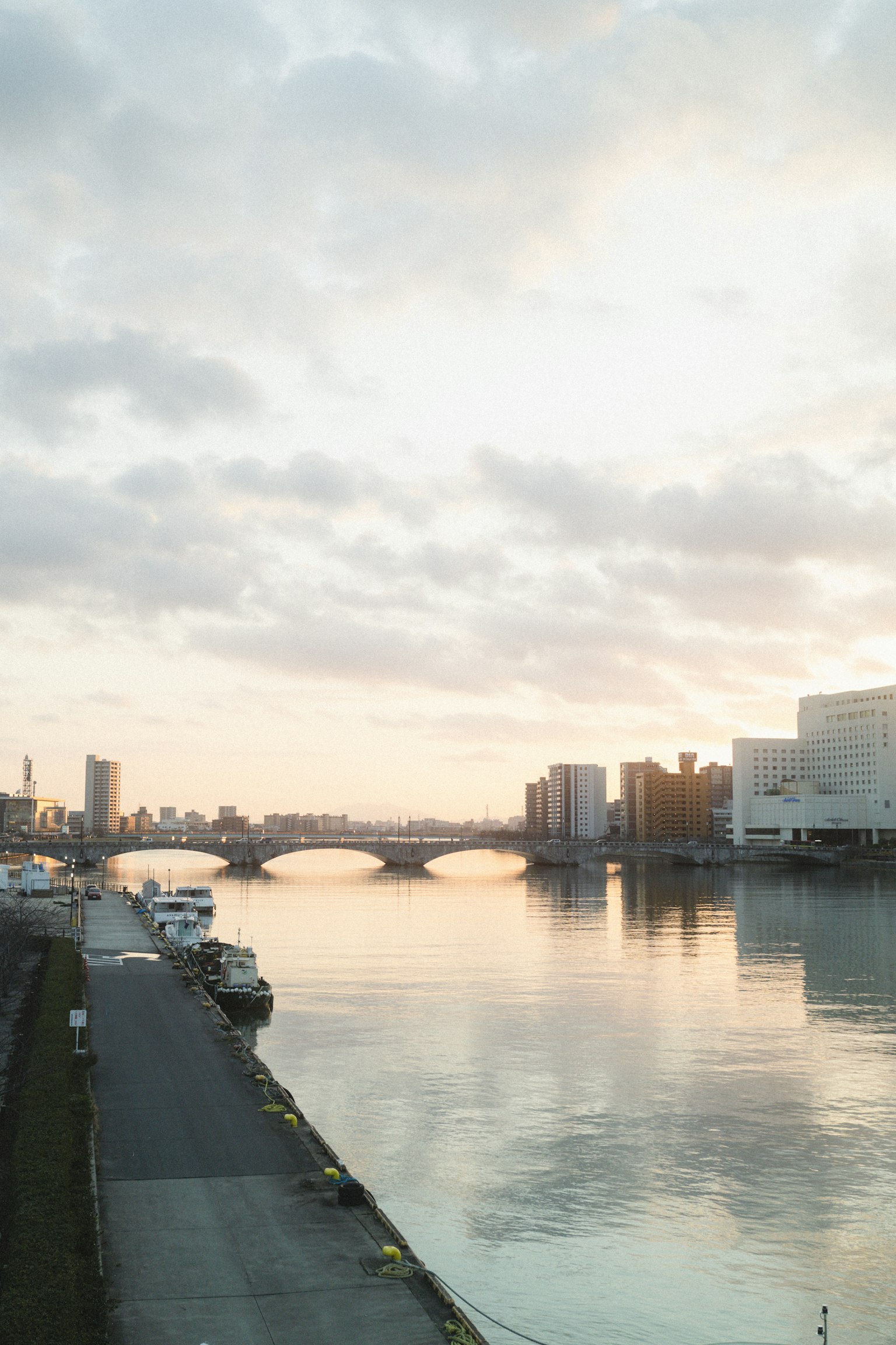 Vista calma del fiume al tramonto con un ponte e lo skyline