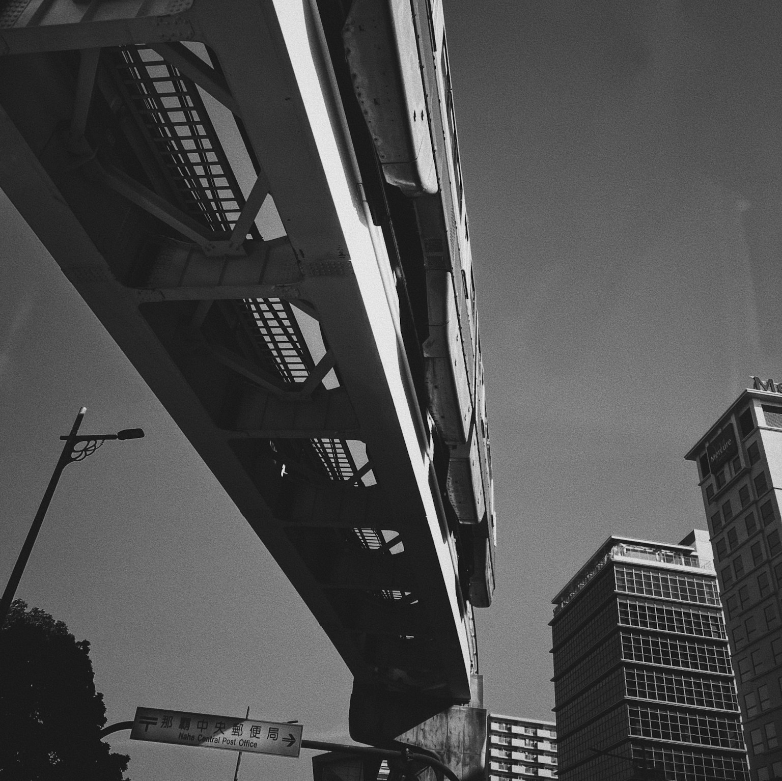 Escena urbana con una estructura de monorraíl elevada sobre edificios modernos
