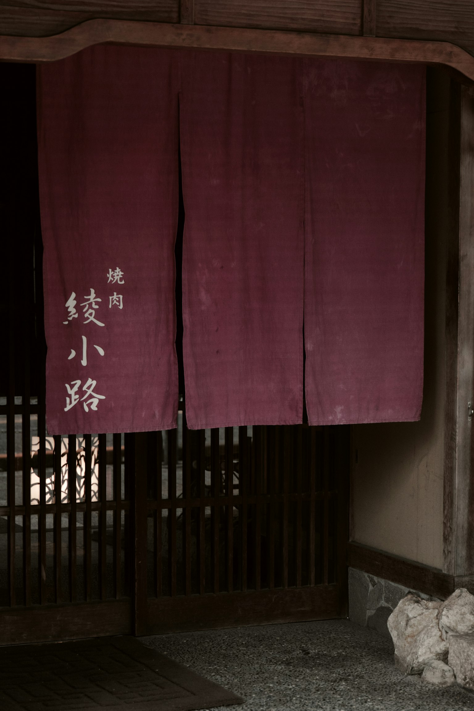 传统日本入口的图像，挂着深紫色的暖帘