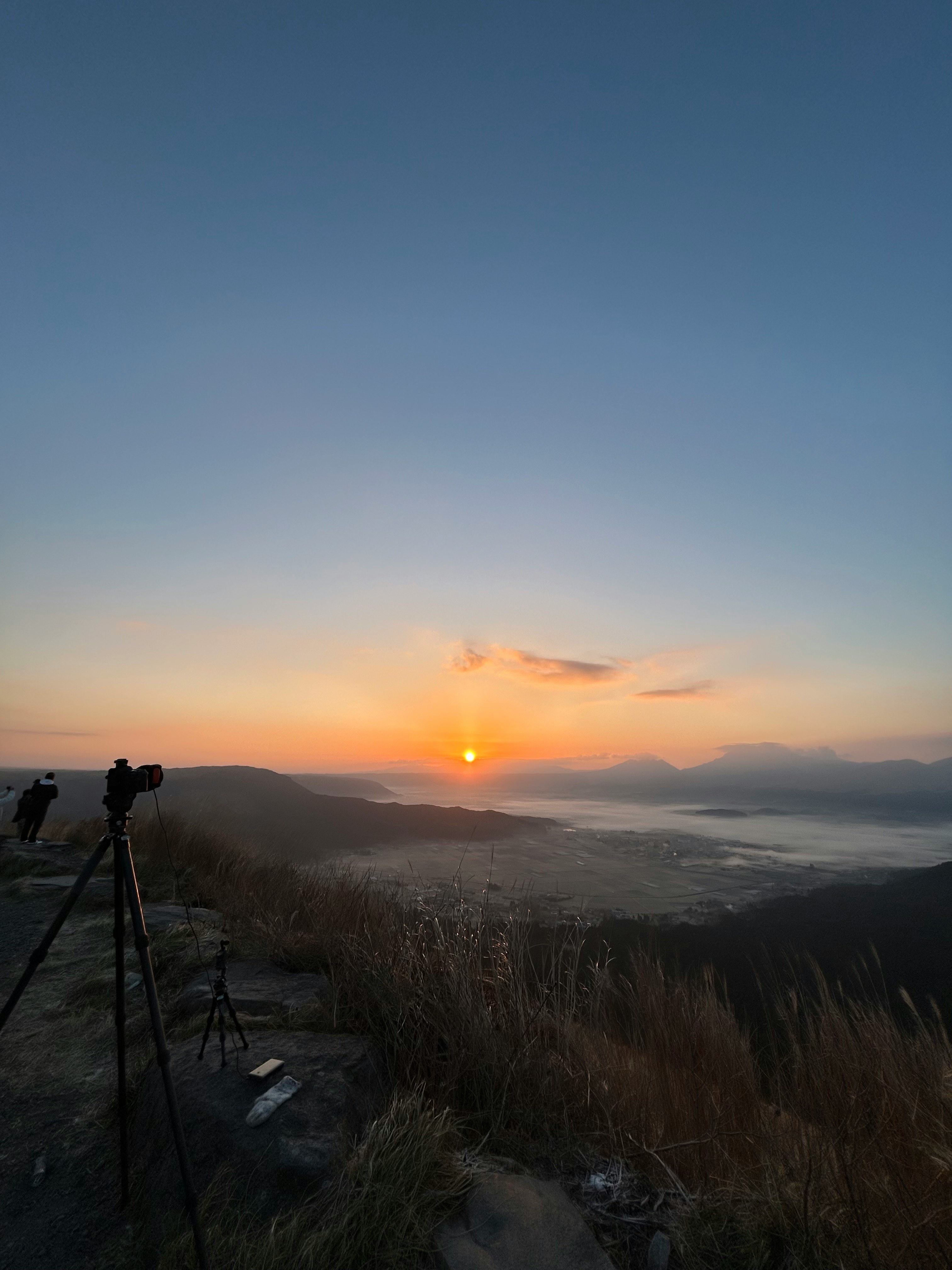 winter seaside sunset with misty mountain ridges