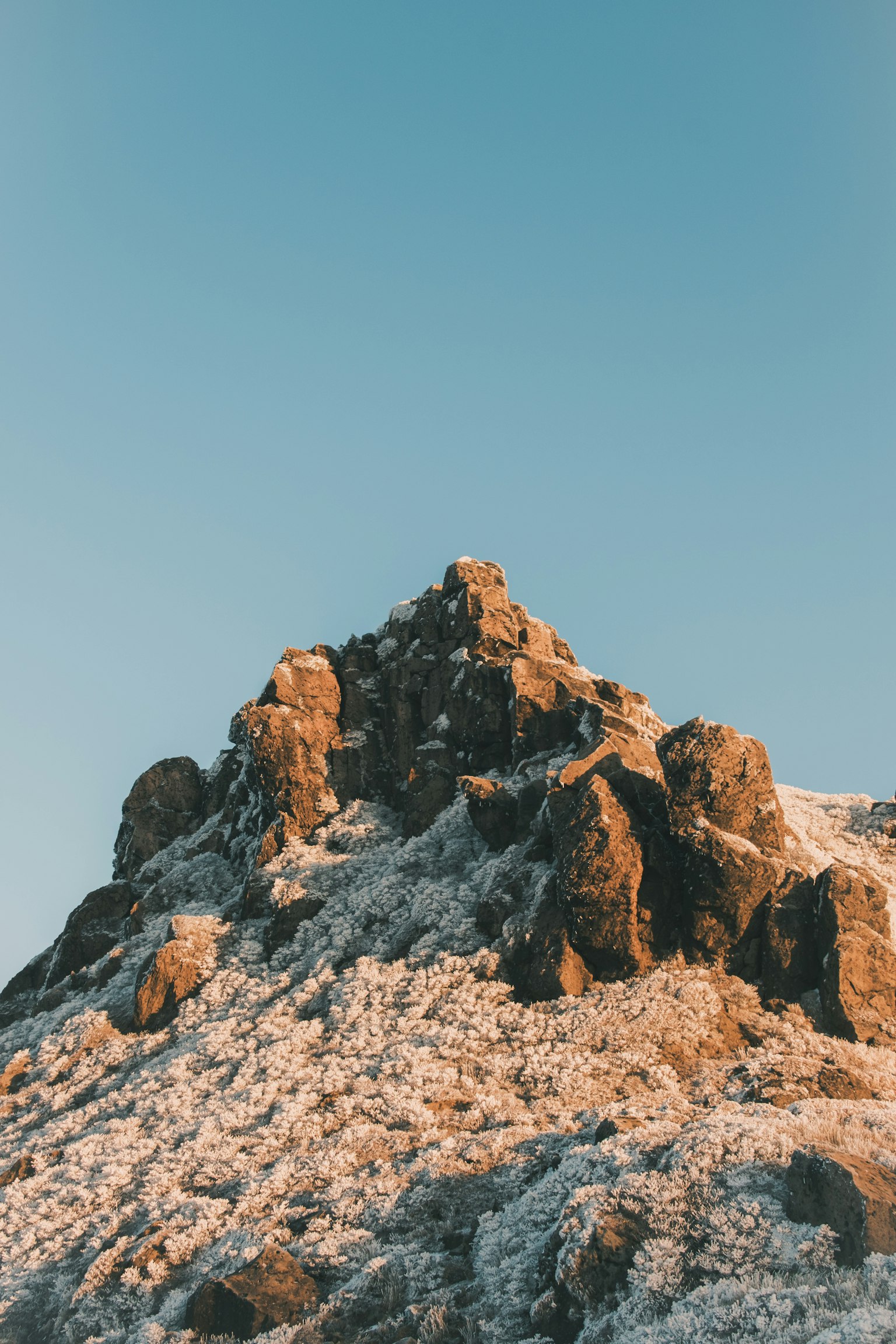 Schneebedeckter Berggipfel vor blauem Himmel