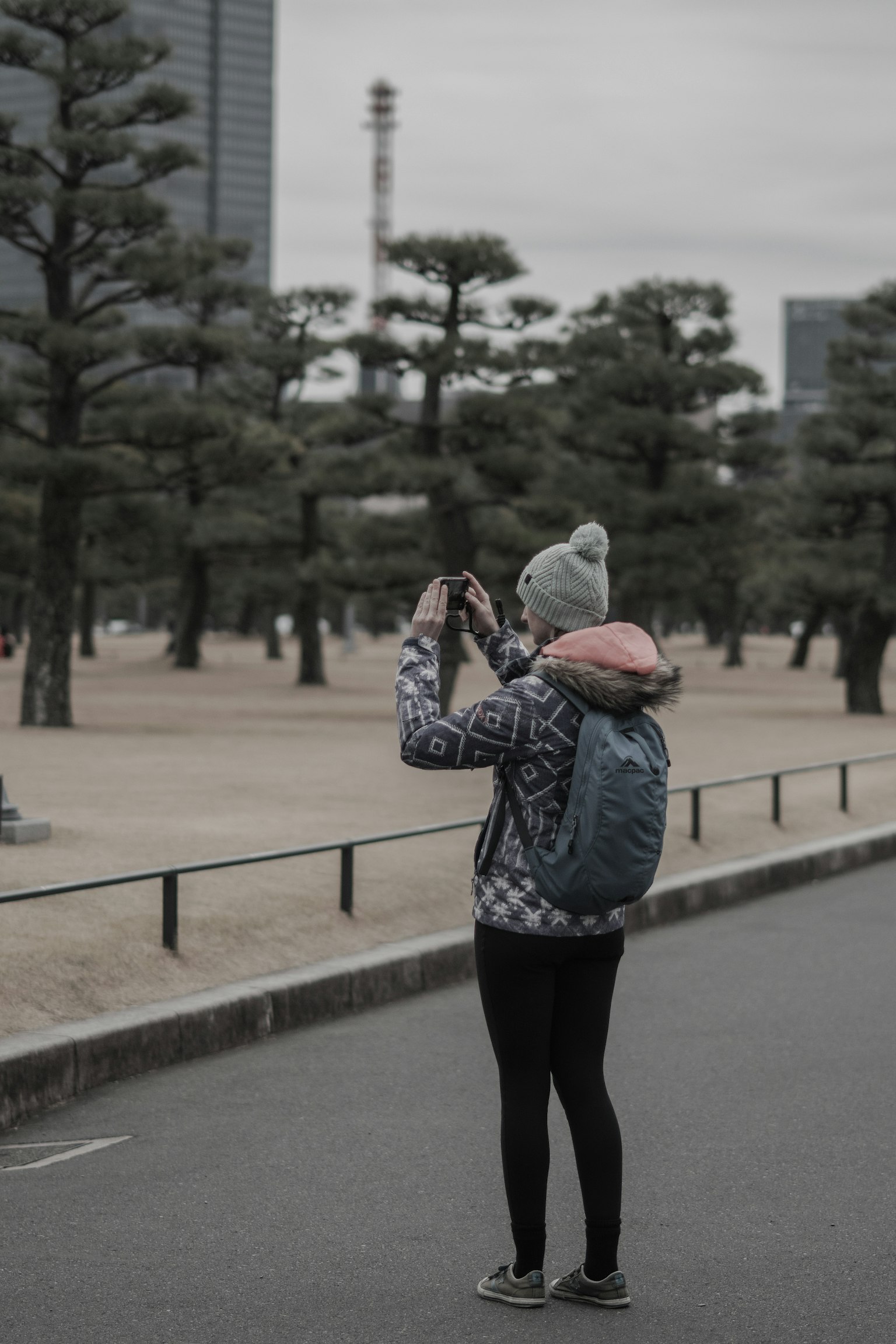 Una mujer tomando fotos en un parque con una cámara