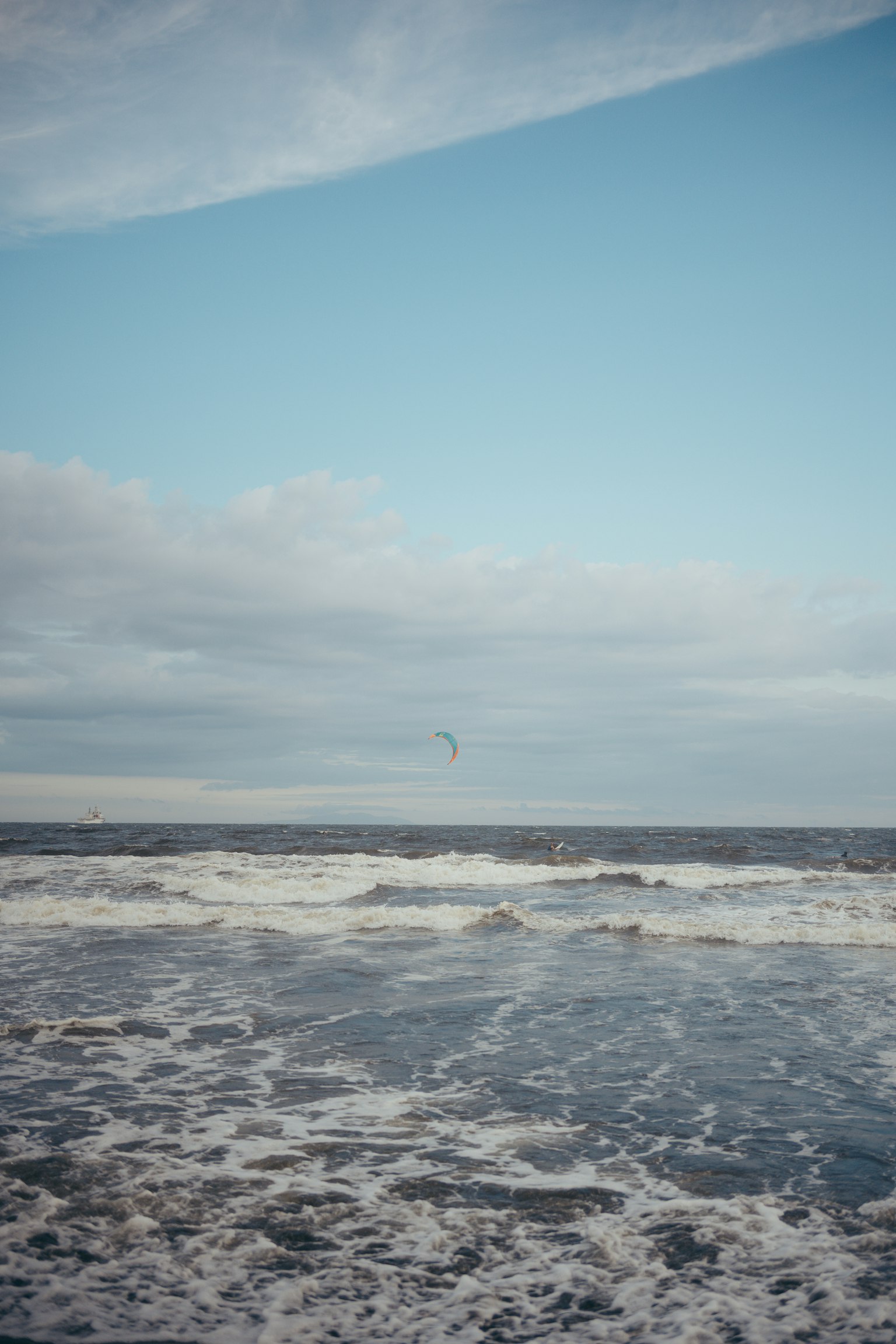 Calm sea with blue sky and waves crashing on the shore