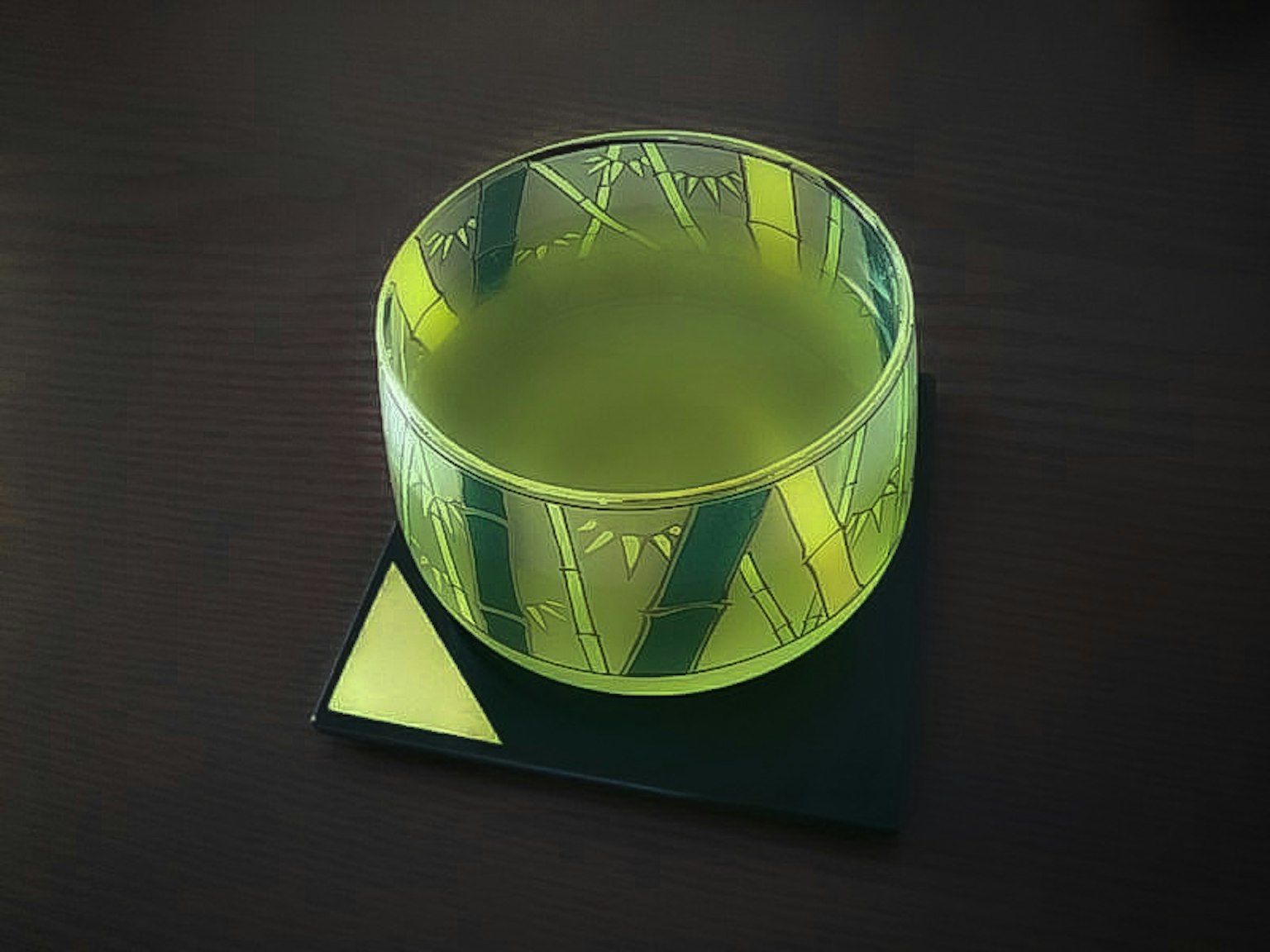 Eine transparente grüne Glasschale auf einer schwarzen Oberfläche mit einem geometrischen Untersetzer
