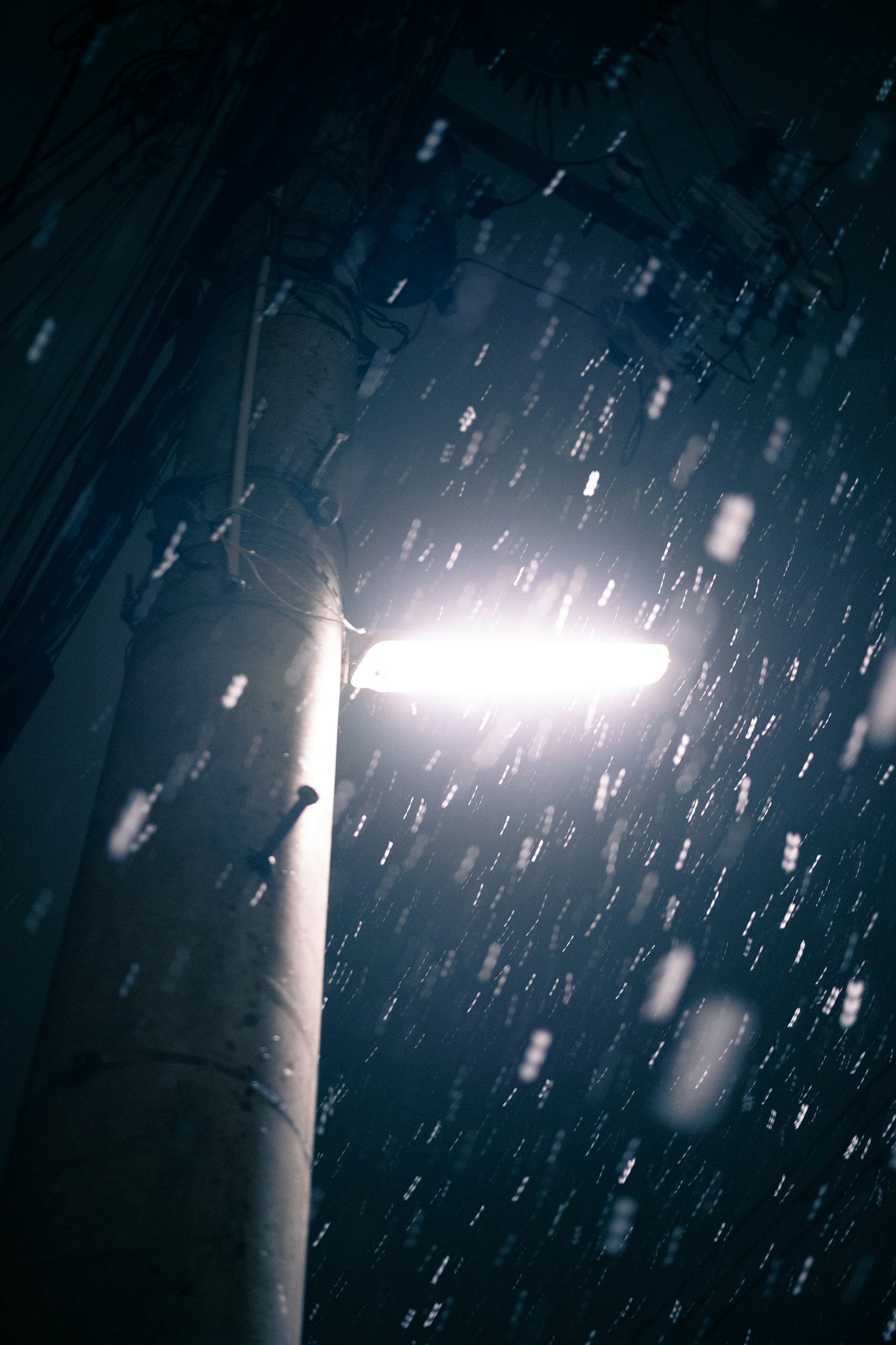 Farola iluminando la nieve que cae por la noche