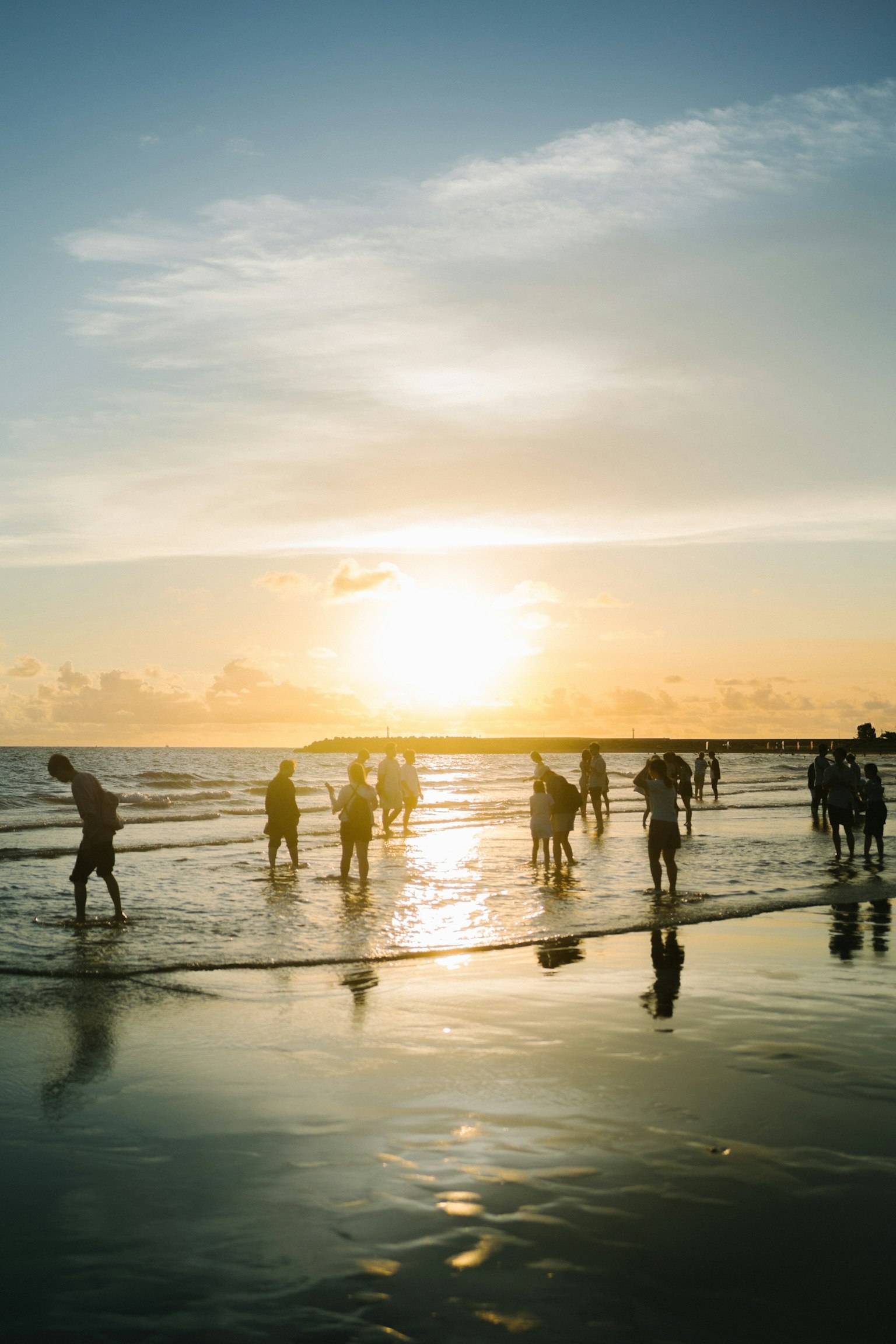 Silhouetten von Menschen, die bei Sonnenuntergang am Strand spielen