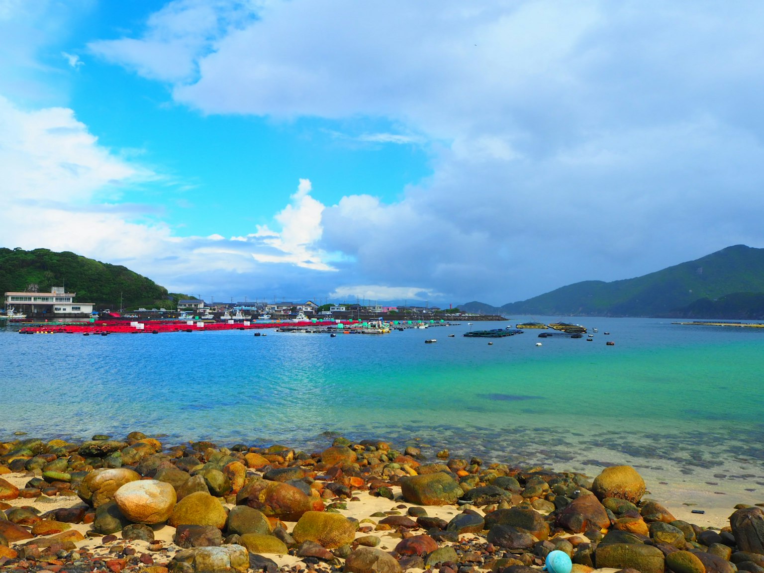 Scenic coastline with blue sky rocky shore and colorful boats