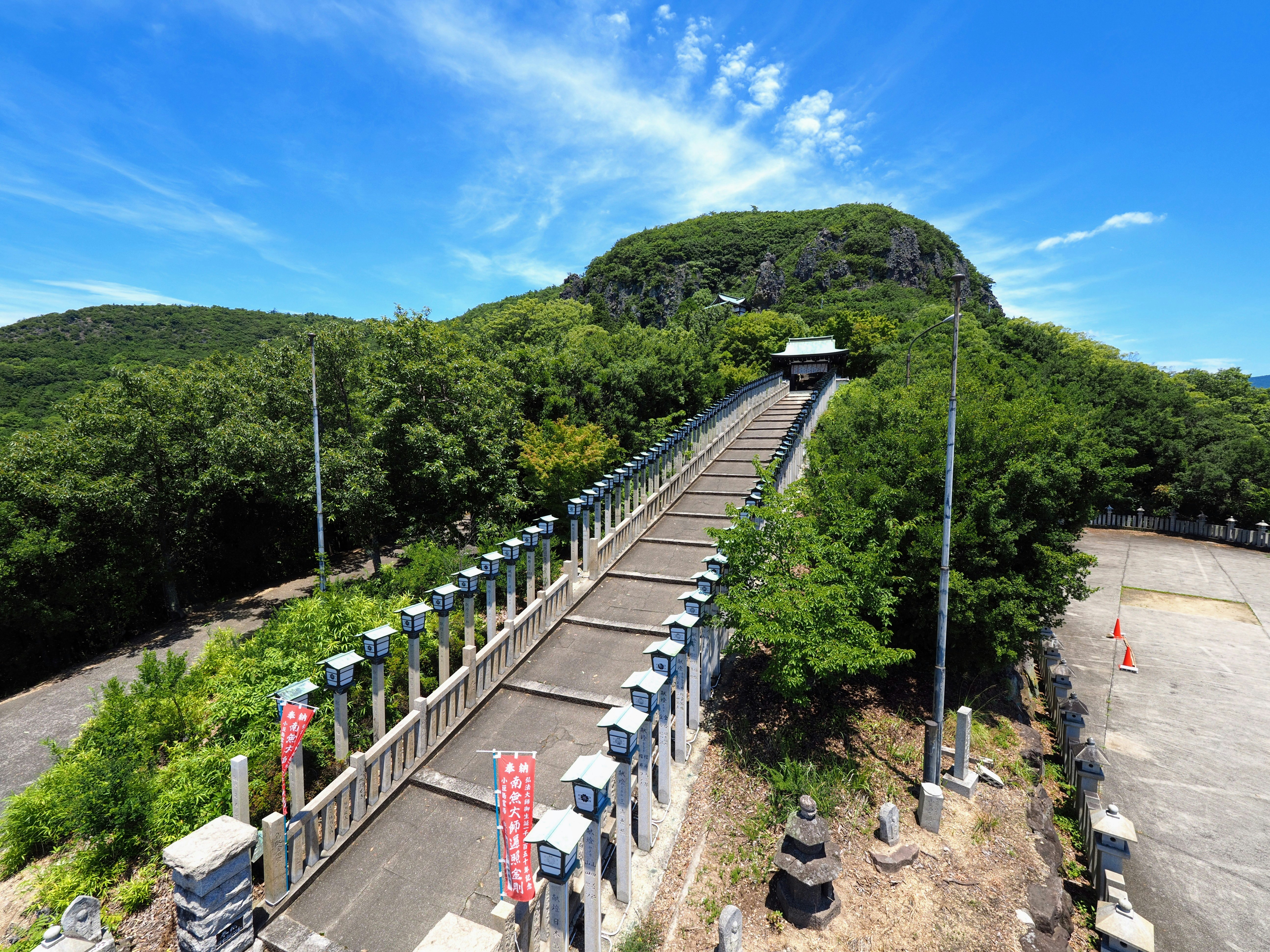 Un sentiero e un punto panoramico su una collina verde sotto un cielo azzurro
