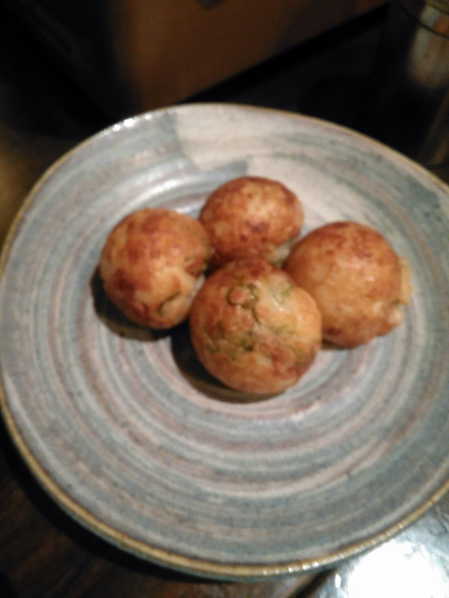 Quatre takoyaki fraîchement cuits sur une assiette