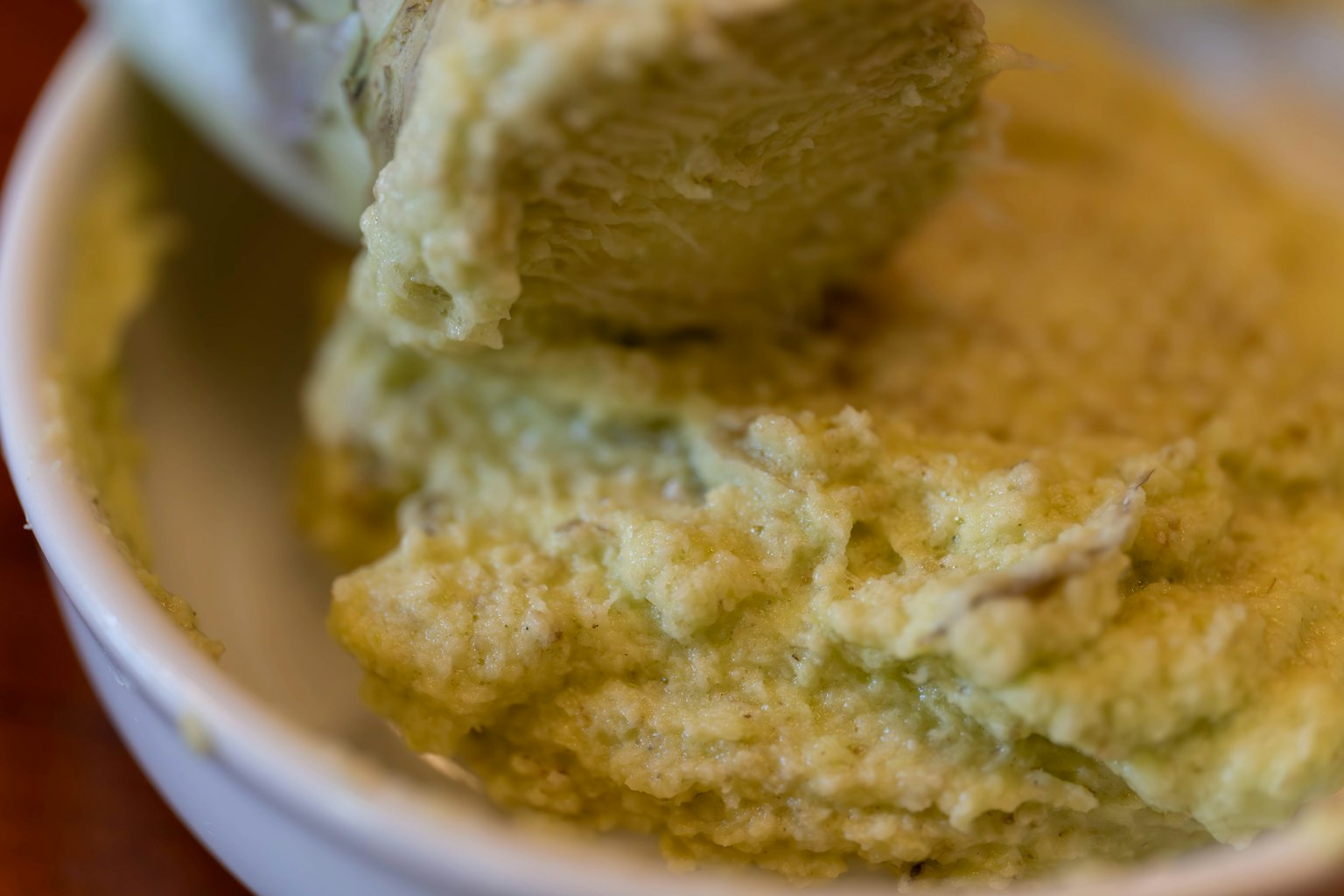 Close-up of a green paste condiment in a white bowl