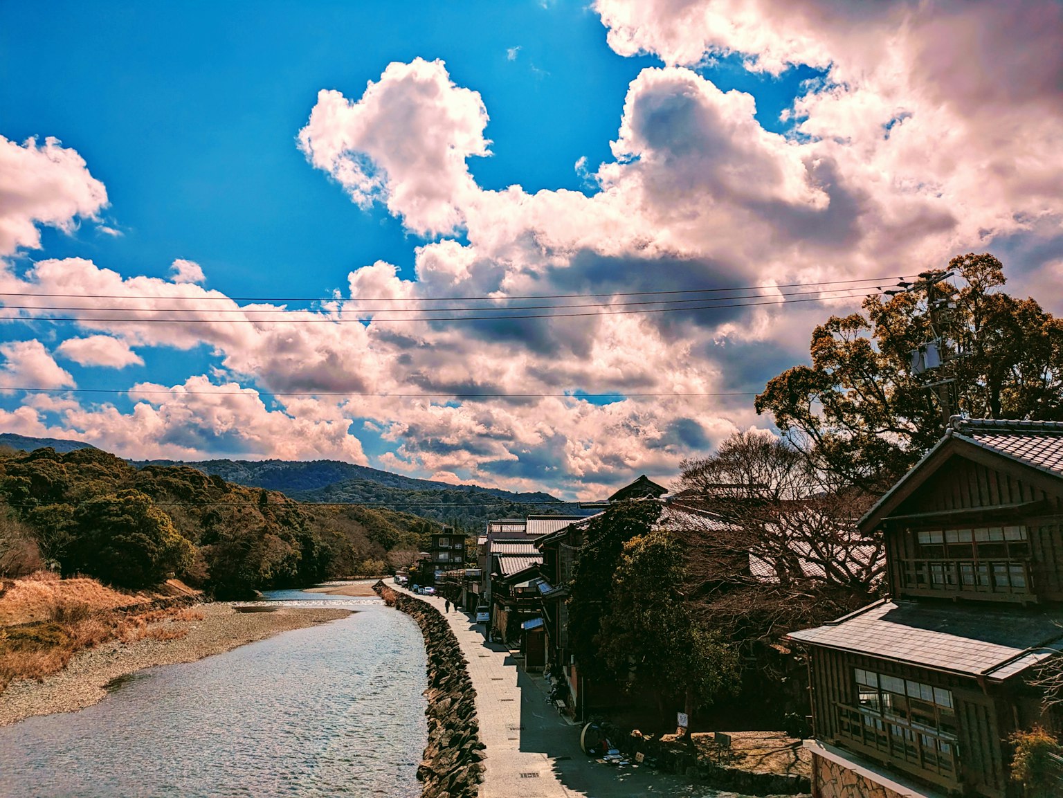 Scenic view of a river with a bright blue sky and clouds alongside traditional buildings