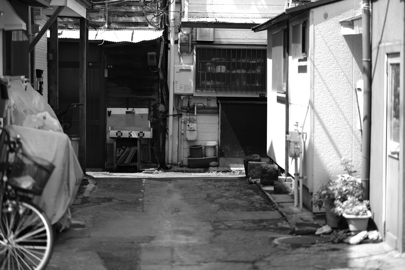 Callejón estrecho con edificios antiguos y una bicicleta en blanco y negro